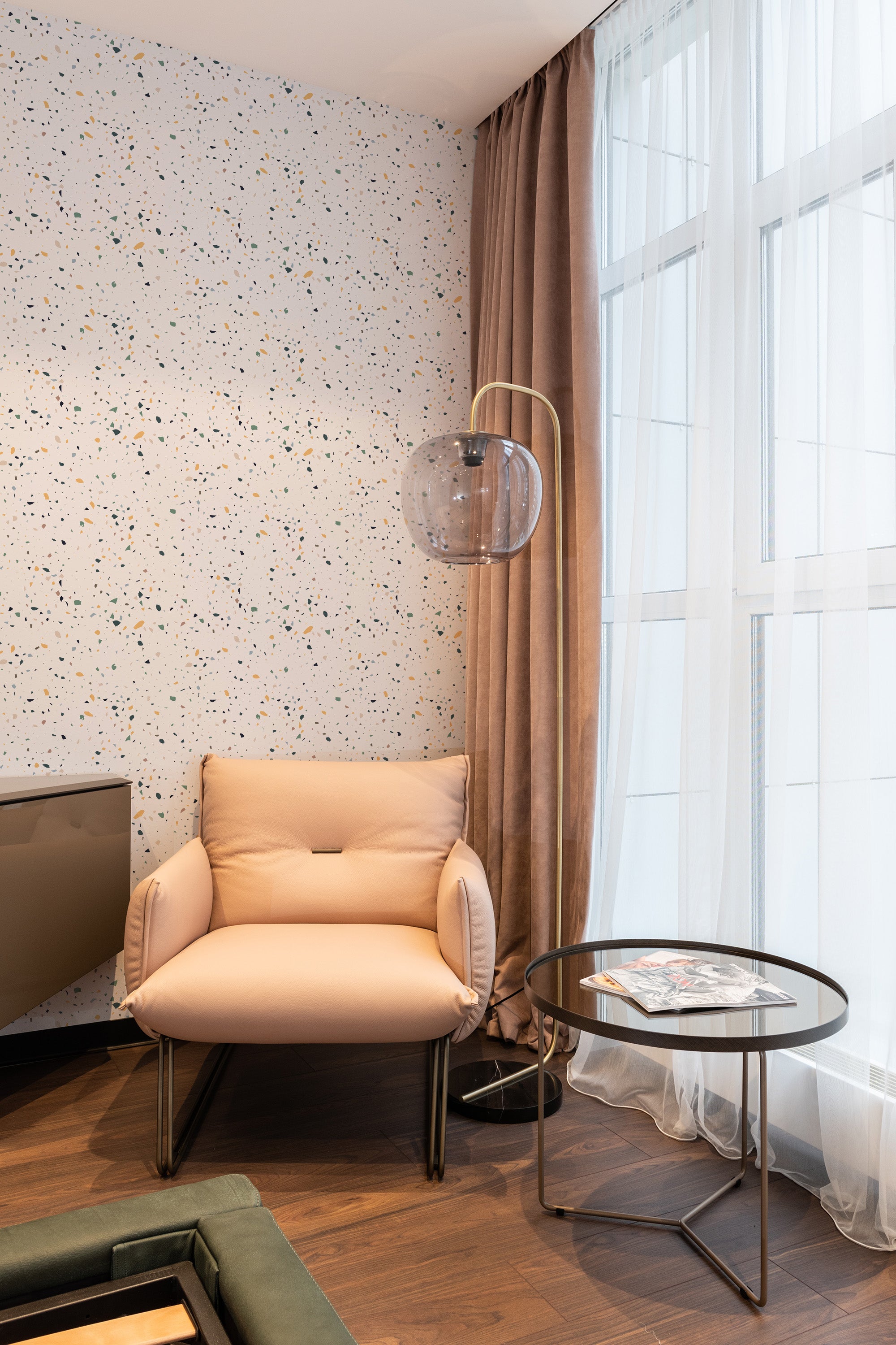 A room with a Terrazzo floor texture design-inspired wallpaper, featuring a speckled pattern with variously sized and colorful stone-like fragments. The wallpaper adds a modern yet timeless touch to the room's decor. Traditional wallpaper.