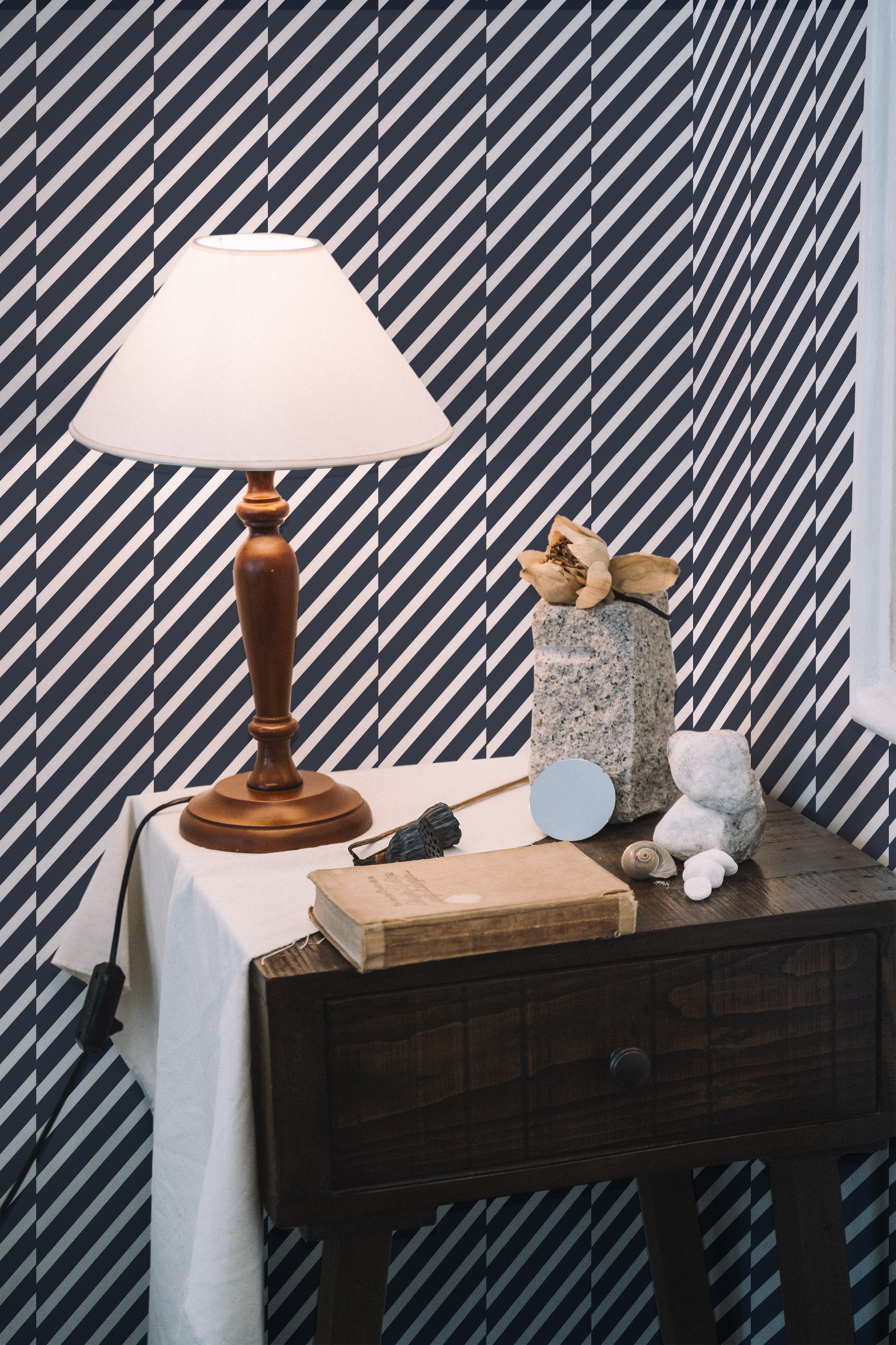 Self-adhesive wallpaper with a Sailor stripes design in alternating diagonal black and white lines, creating a bold and modern visual effect.