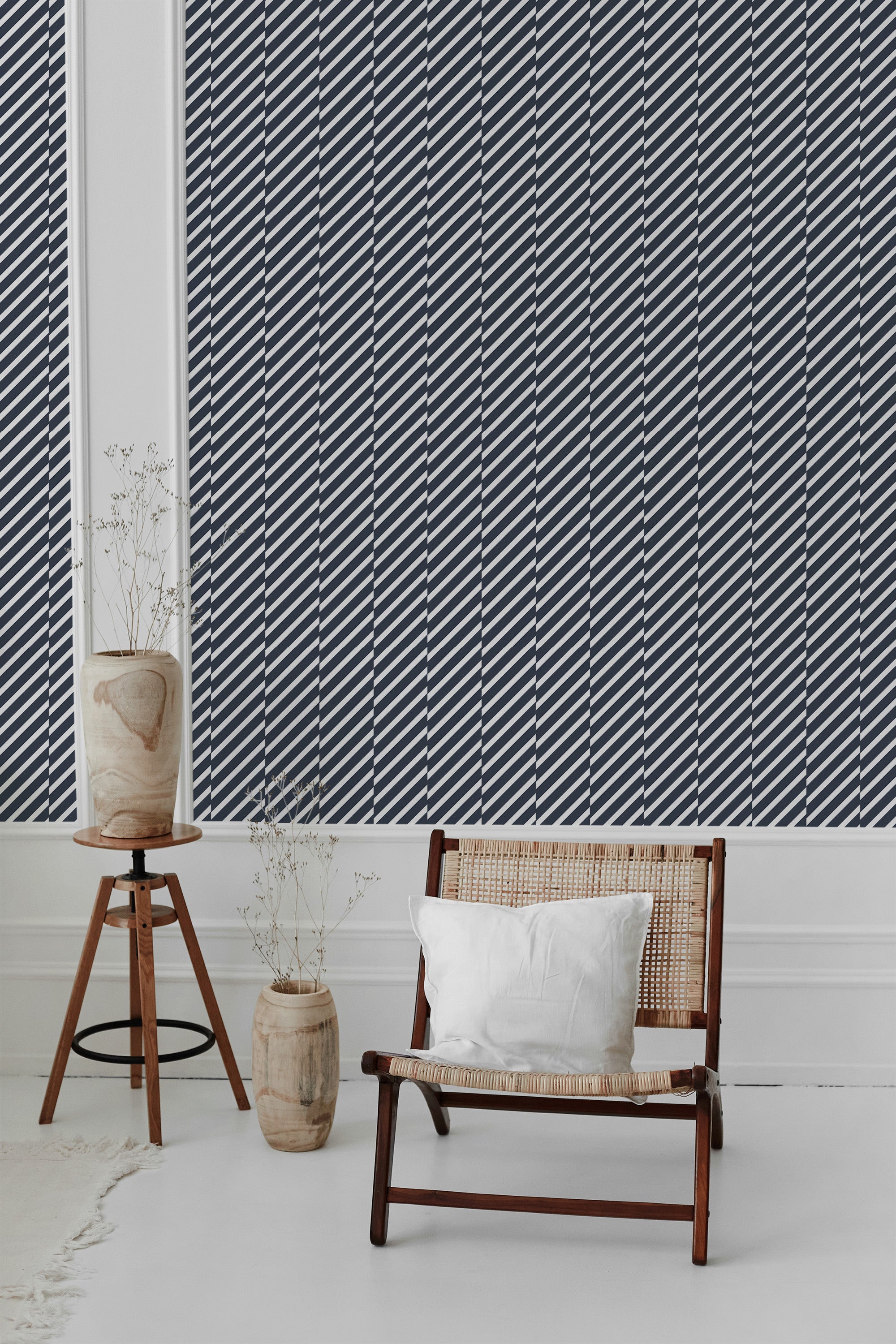 A room with a dark blue striped wallpaper patterned with evenly spaced, diagonal white lines resembling sailor stripes. The design adds a nautical theme to the room, offering a modern yet classic aesthetic that fits well with simple, natural furnishings. Traditional wallpaper.