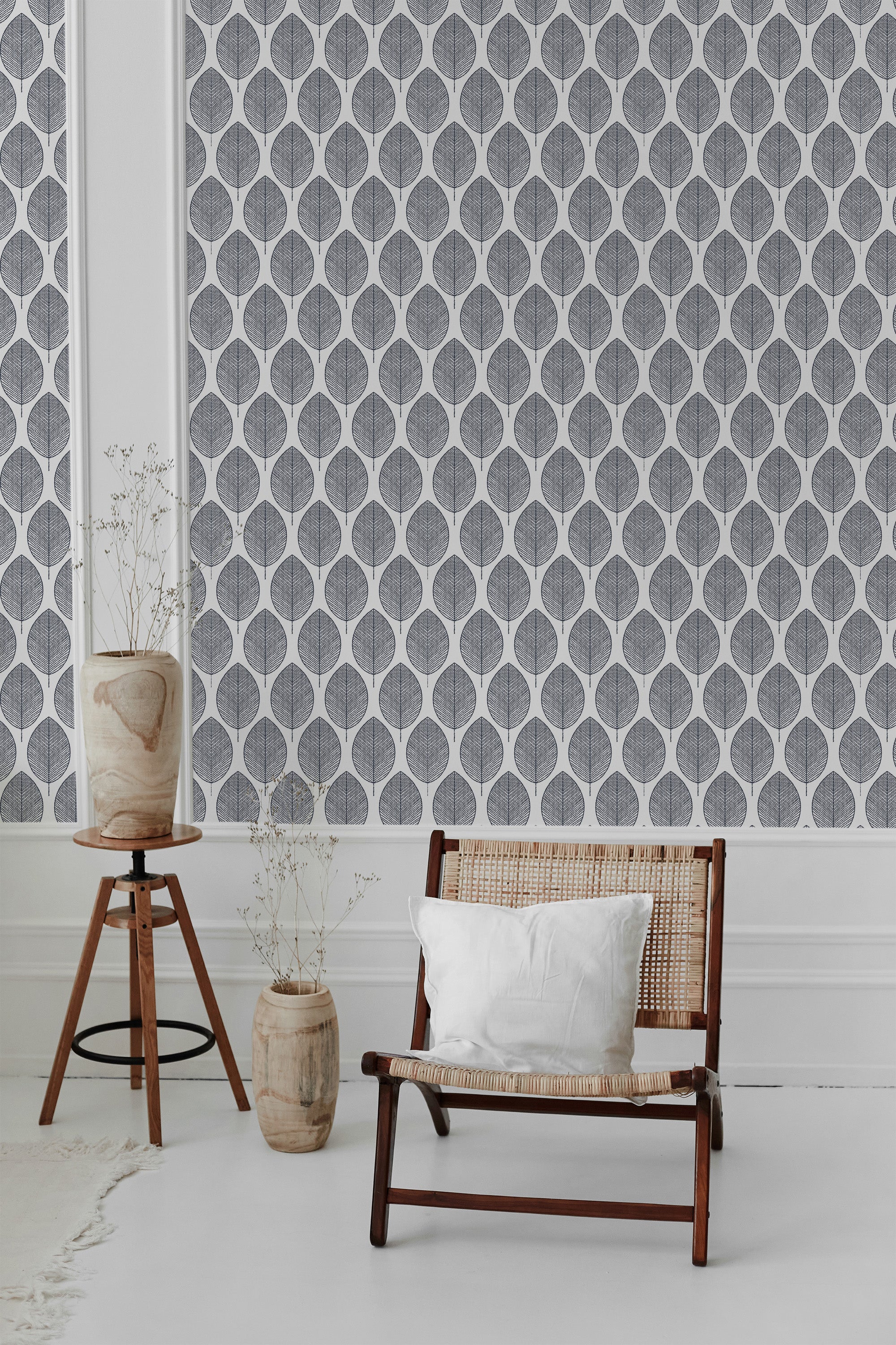 Grey wallpaper with a repetitive pattern of stylized botanical leaf shapes set in a white, symmetrical grid. Traditional wallpaper.