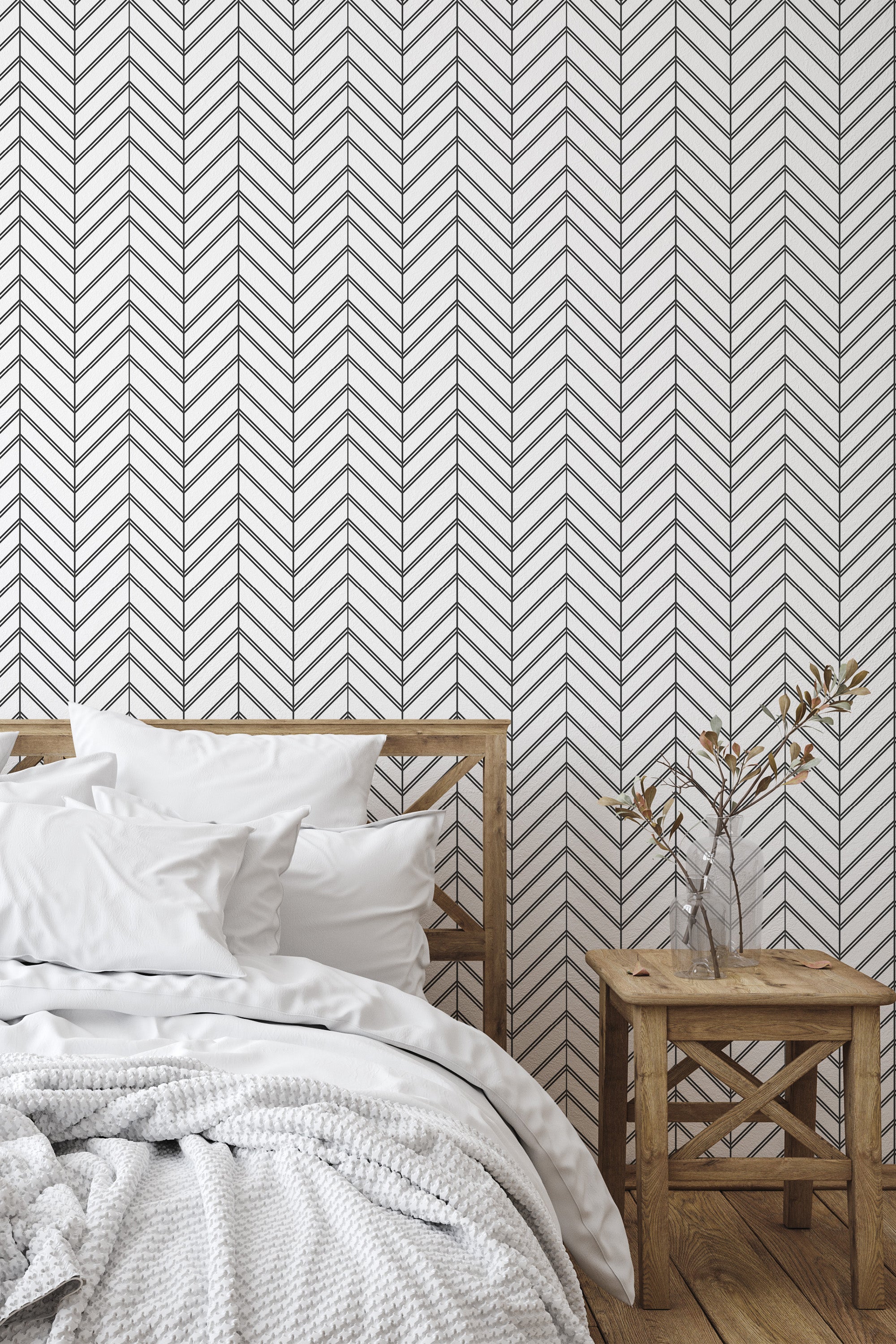 Self-adhesive geometric herringbone wallpaper with black zig-zagging lines on a light background, creating a modern and clean aesthetic in the room.