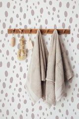 Self-adhesive wallpaper with a playful drops pattern in various sizes, scattered across the wall in a light, neutral color palette.