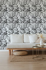 Black and white wallpaper with an intricate pattern of dots and lines creating an abstract, swirling design on the wall behind a neutral-toned sofa. Traditional wallpaper.