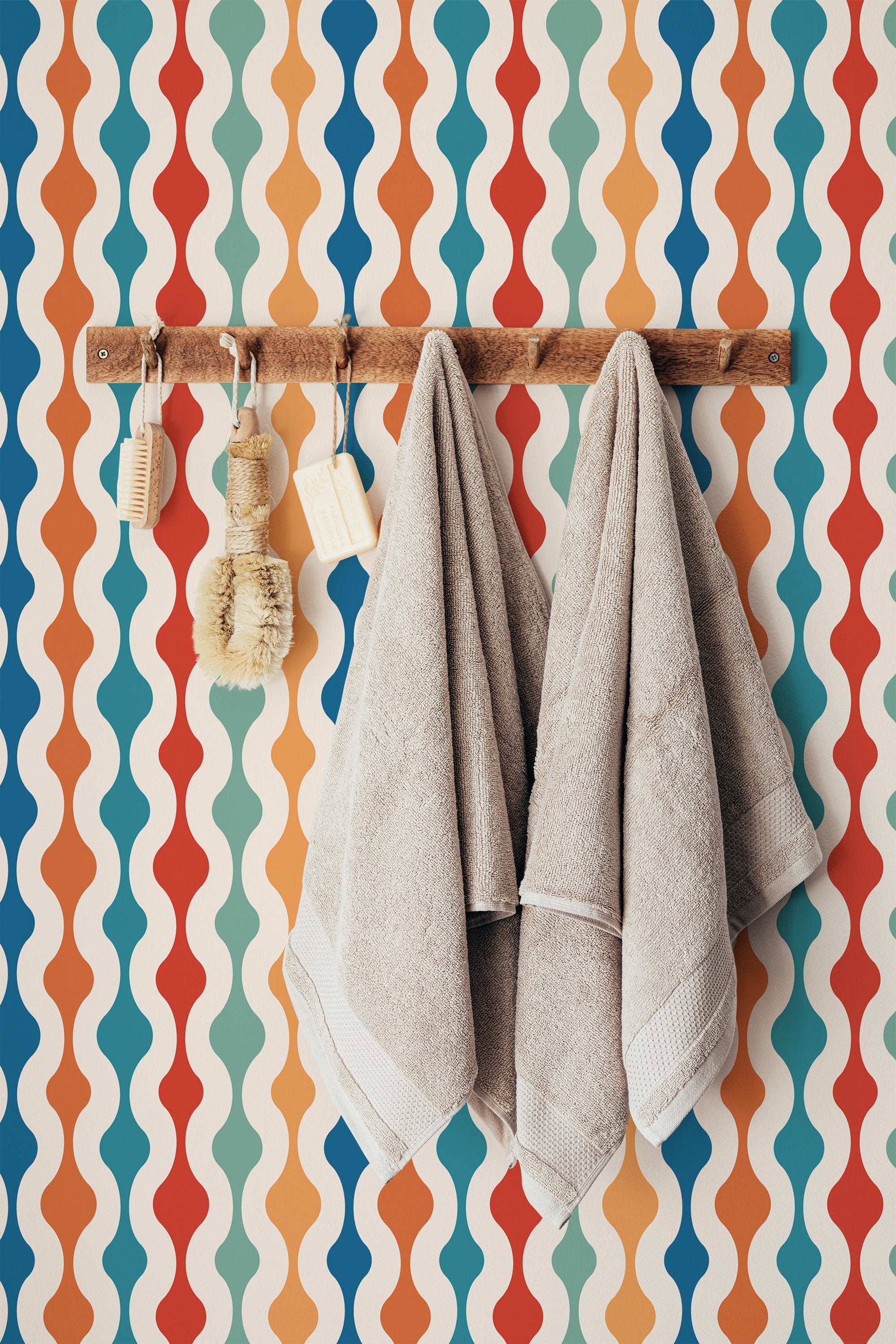 Self-adhesive wallpaper with a colorful retro design made up of wavy vertical stripes in shades of orange, blue, red, and cream.
