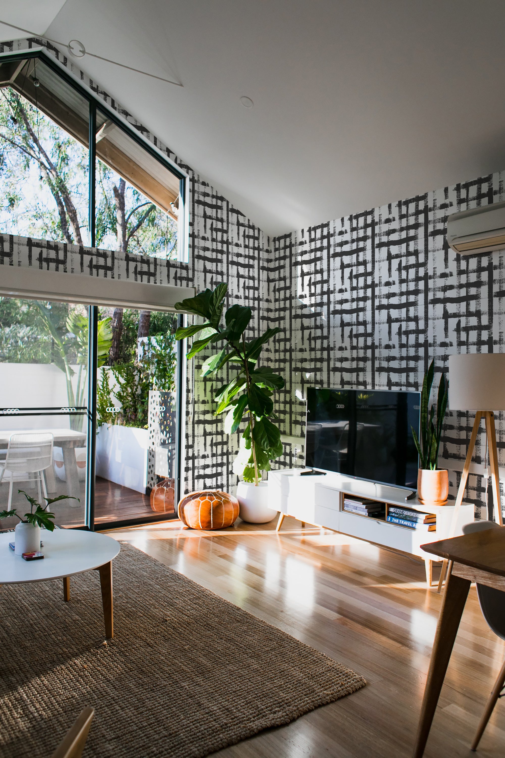 Room with a gray and white wallpaper design featuring abstract brush lines, resembling a grid-like pattern, covering the wall. Traditional wallpaper.