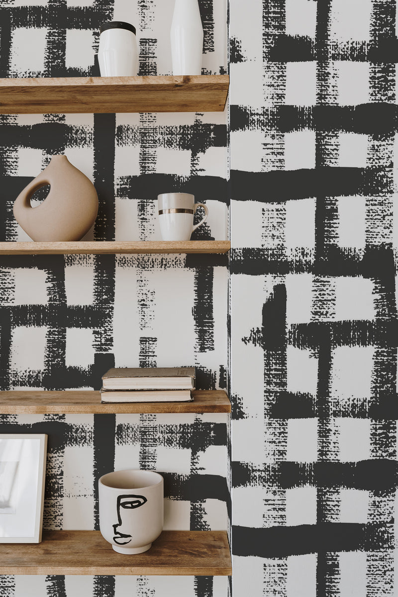 Self-adhesive wallpaper with a bold black and white brush lines pattern, creating an abstract grid-like design on the wall.