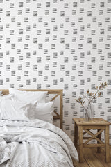 Self-adhesive wallpaper with a minimalist pattern of horizontal short black lines arranged in staggered rows on a white background, adding a subtle modern touch to the room.