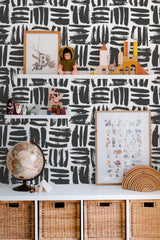 Self-adhesive wallpaper with a black brush stroke pattern on a white background, creating a bold, modern look in the room.