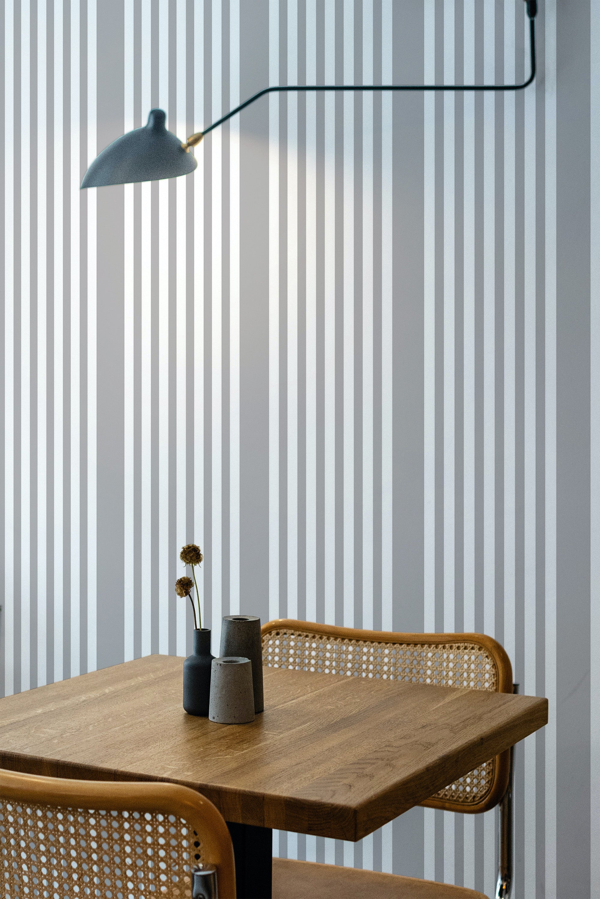 Self-adhesive wallpaper with a classic French ticking stripe design in neutral tones of light gray and white running vertically.
