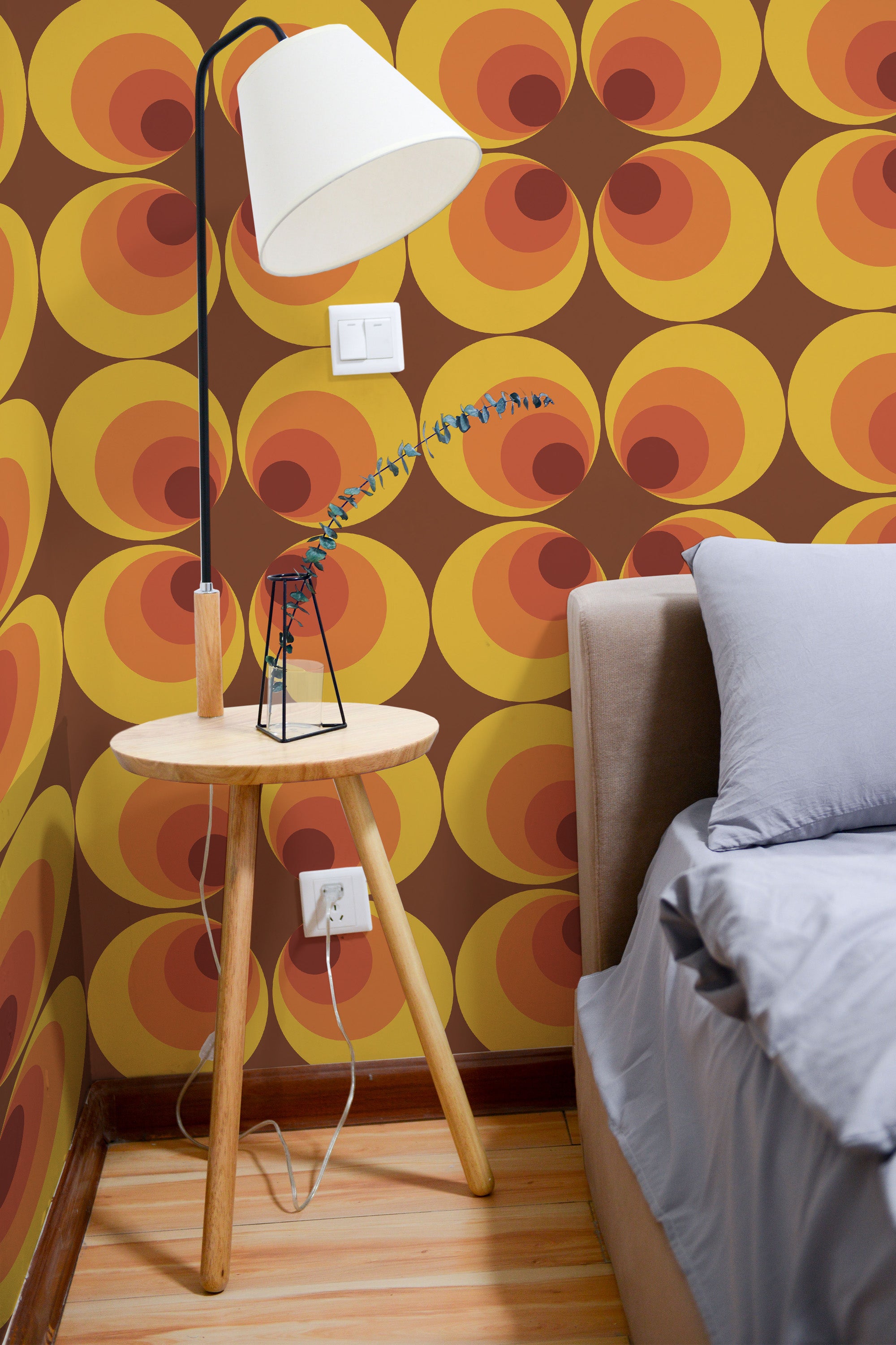 Self-adhesive geometric retro wallpaper with bold circular patterns in shades of orange, yellow, and brown, creating a 70s-inspired, vibrant color scheme on the room���s accent wall.