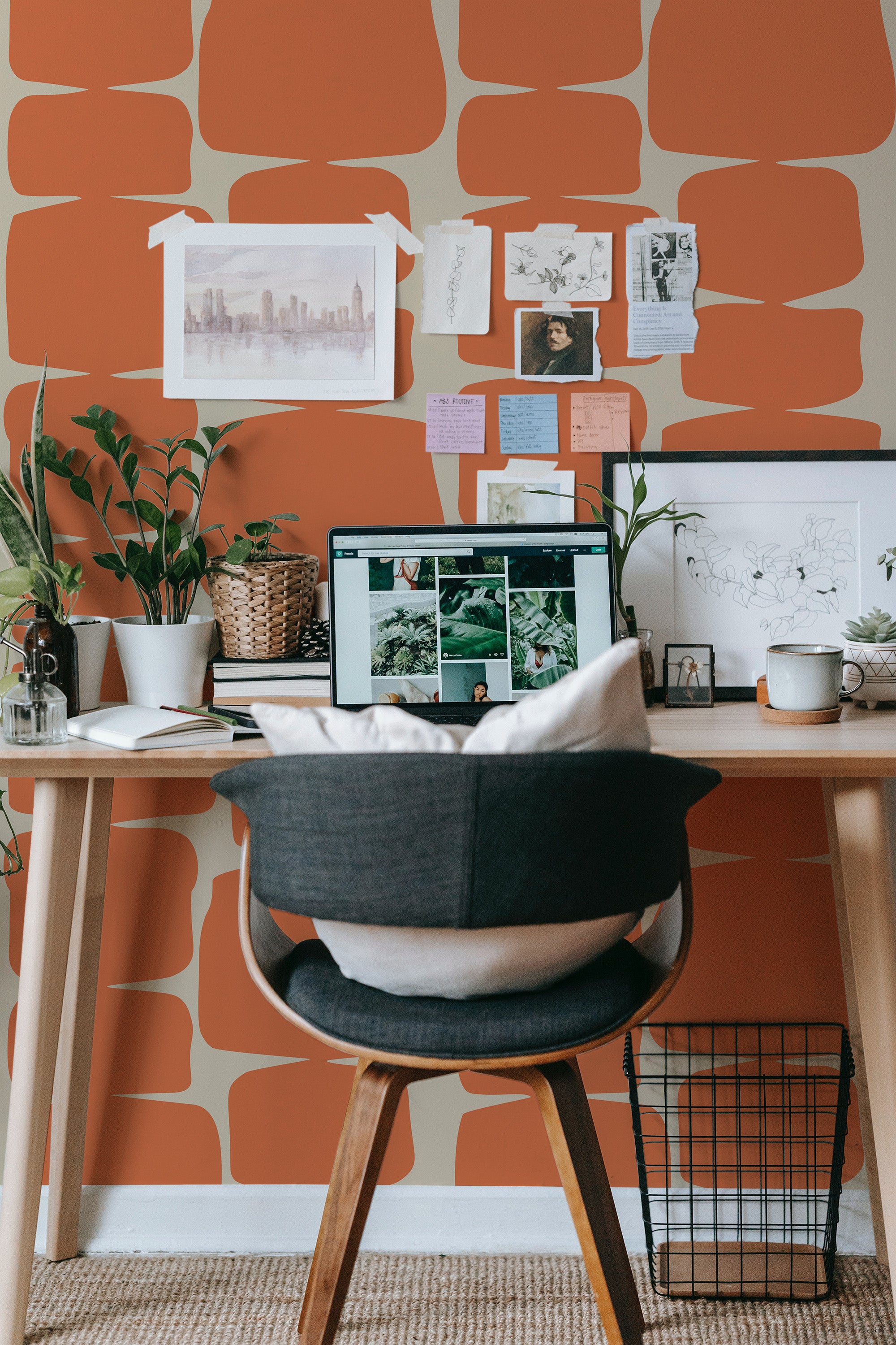 Self-adhesive wallpaper with a retro shapes design in bold orange and beige tones, adding a vintage vibe to a cozy workspace with plants, art, and a wooden desk.