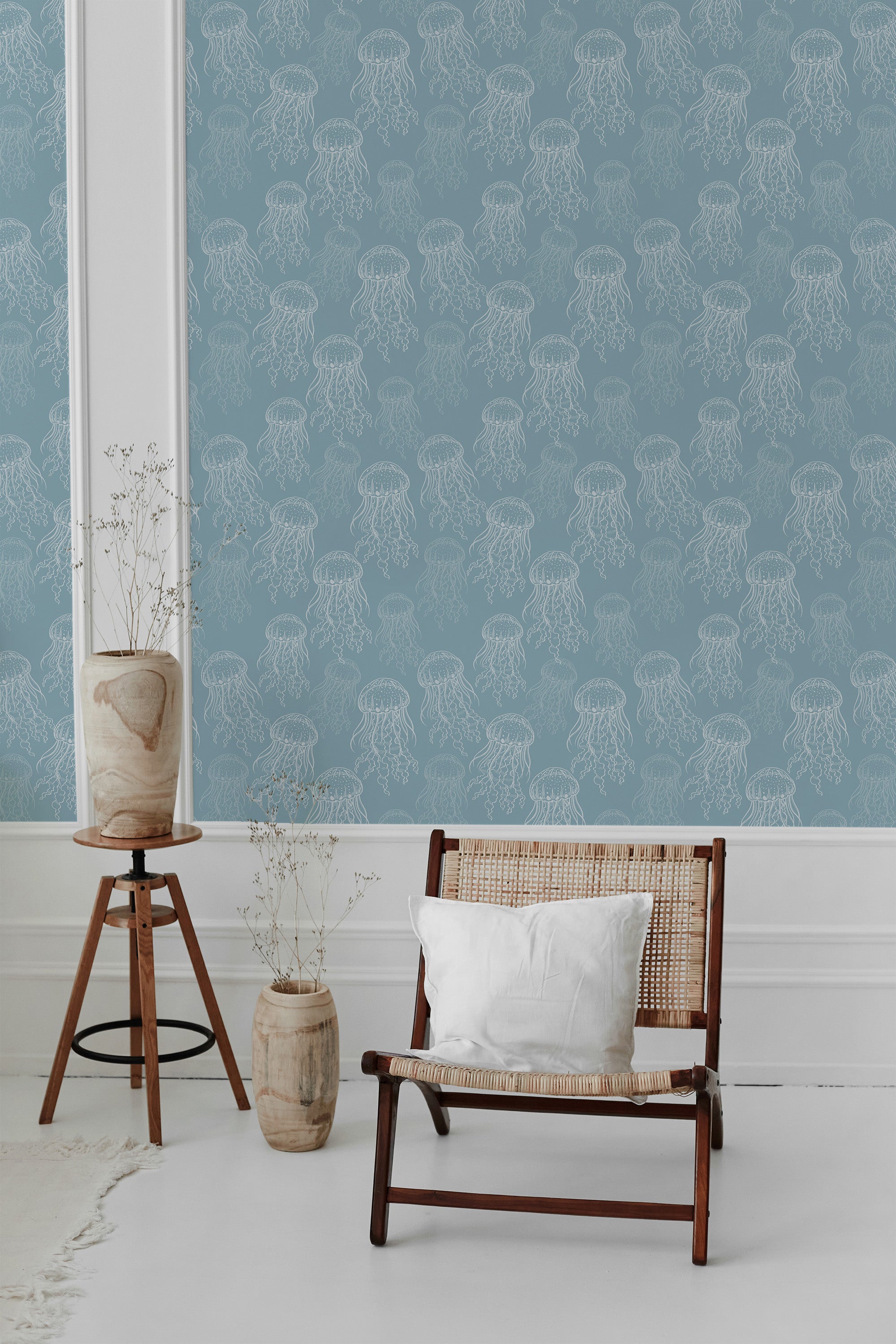 Blue wallpaper adorned with a white jellyfish pattern, complemented by a chair, potted plants, and decorative vases in a bright room with white accents. This is traditional wallpaper.