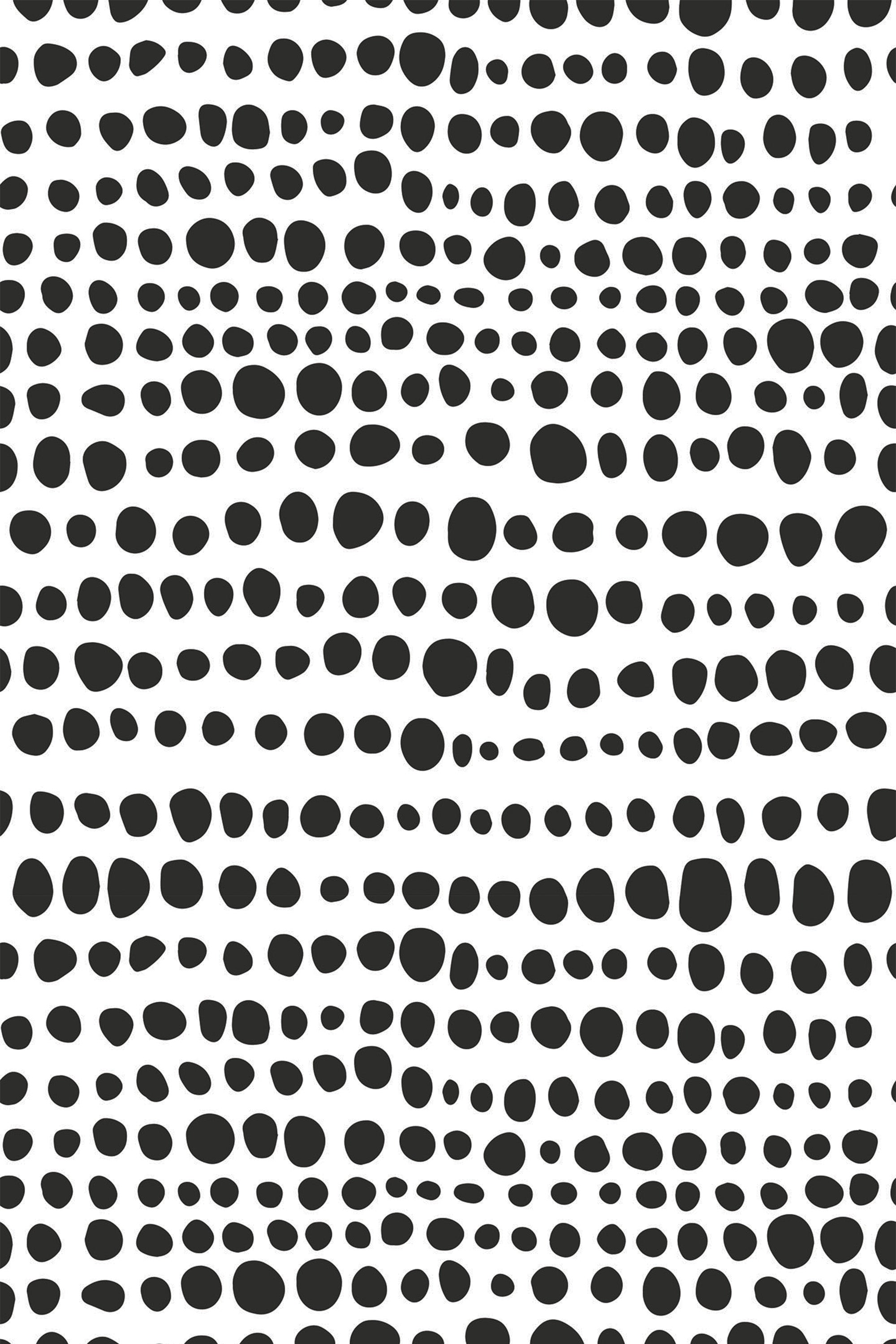 Black irregular polka dots scattered across a white background. Peel and stick removable wallpaper.
