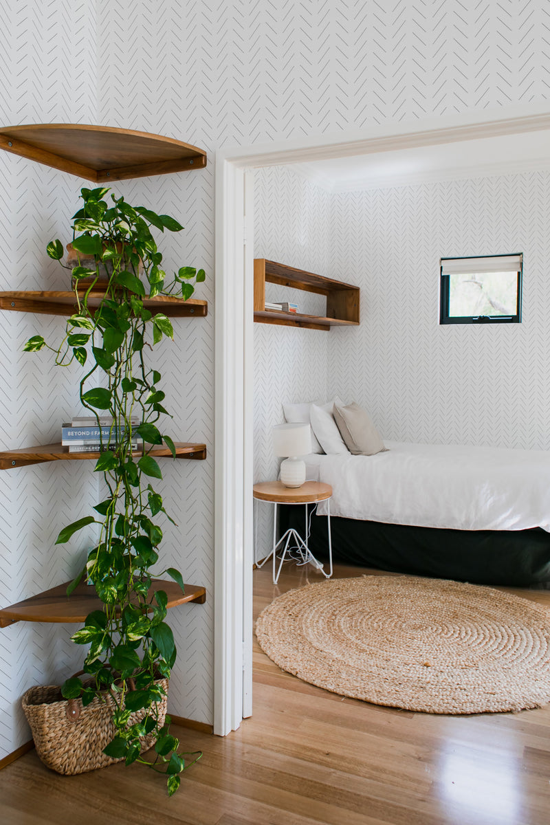 bedroom cozy interior green plants round carpet simple herringbone peel & stick wallpaper