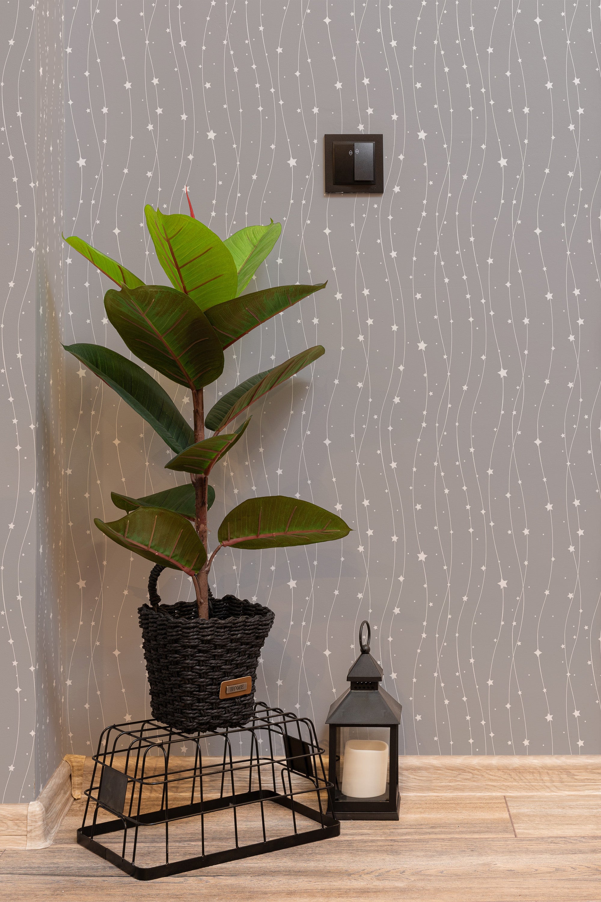 Self-adhesive wallpaper in a vertical star line design with delicate, wavy lines and small white star motifs on a soft, muted gray background.