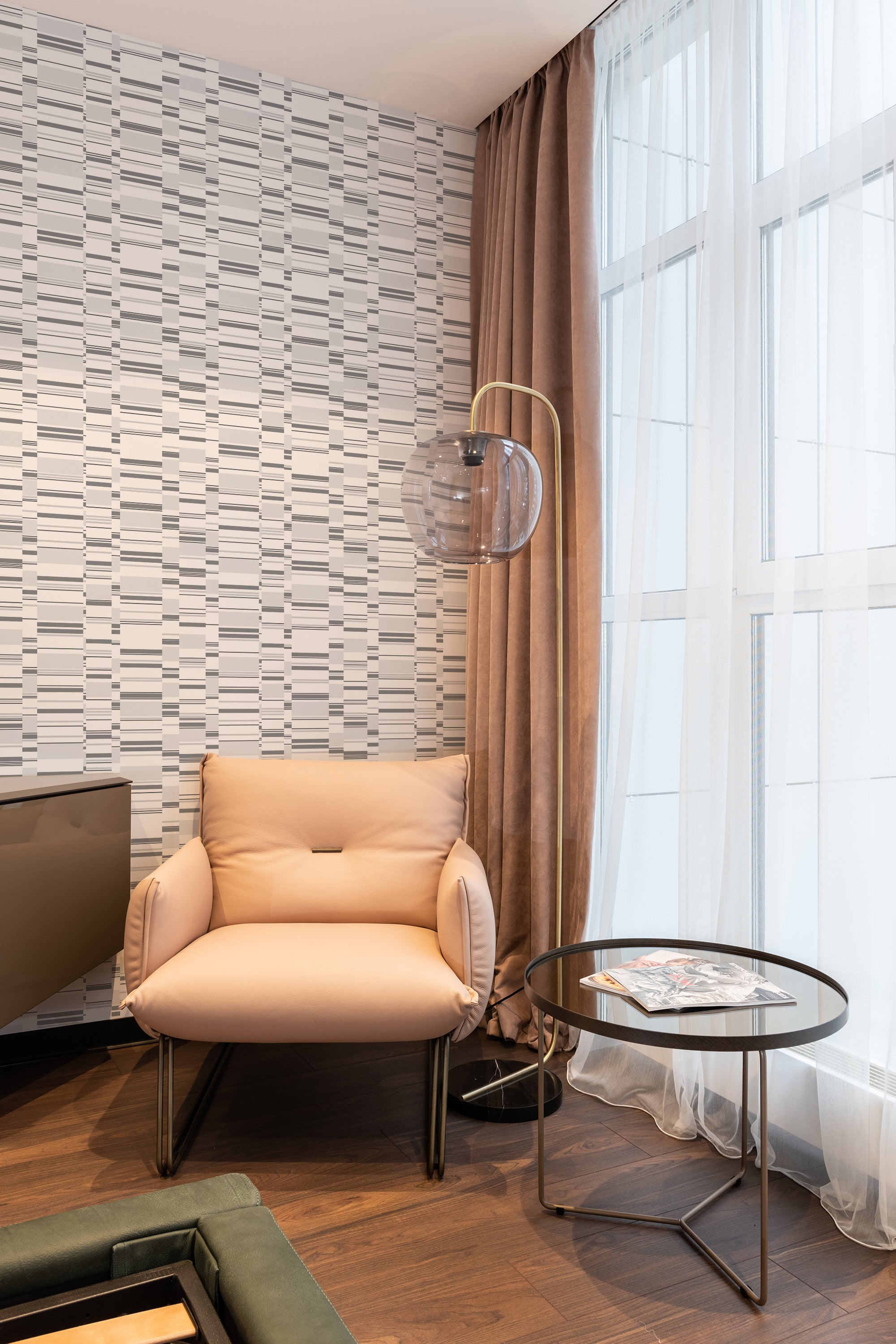 A modern room with a wall adorned in gray abstract stripes wallpaper, characterized by staggered horizontal and vertical lines creating a geometric pattern. The neutral tones complement the contemporary decor, blending seamlessly with the room���s sleek furniture. Traditional wallpaper.