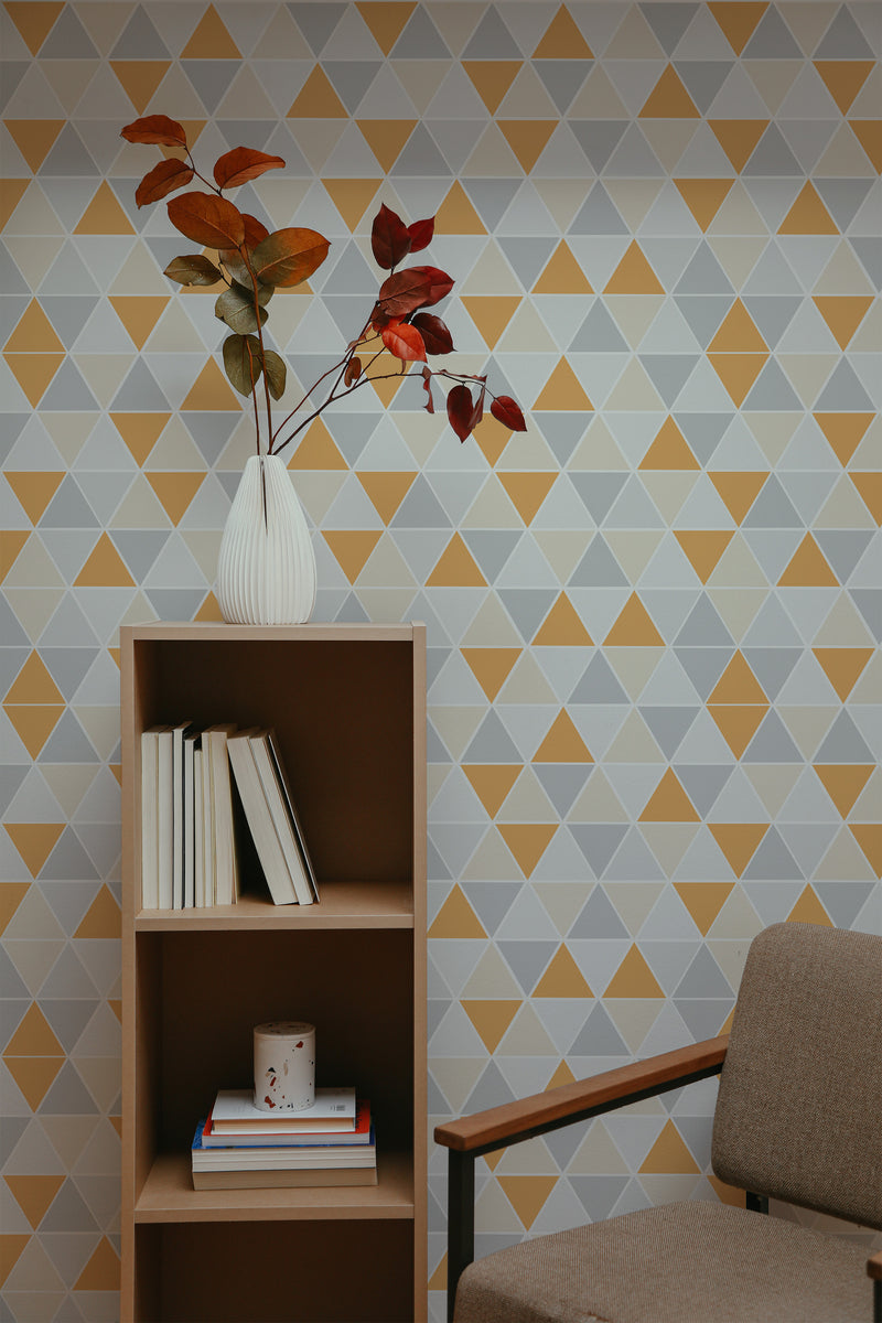 Self-adhesive wallpaper with a triangular geometric pattern in shades of yellow, gray, and white, creating a modern and stylish look in the room.