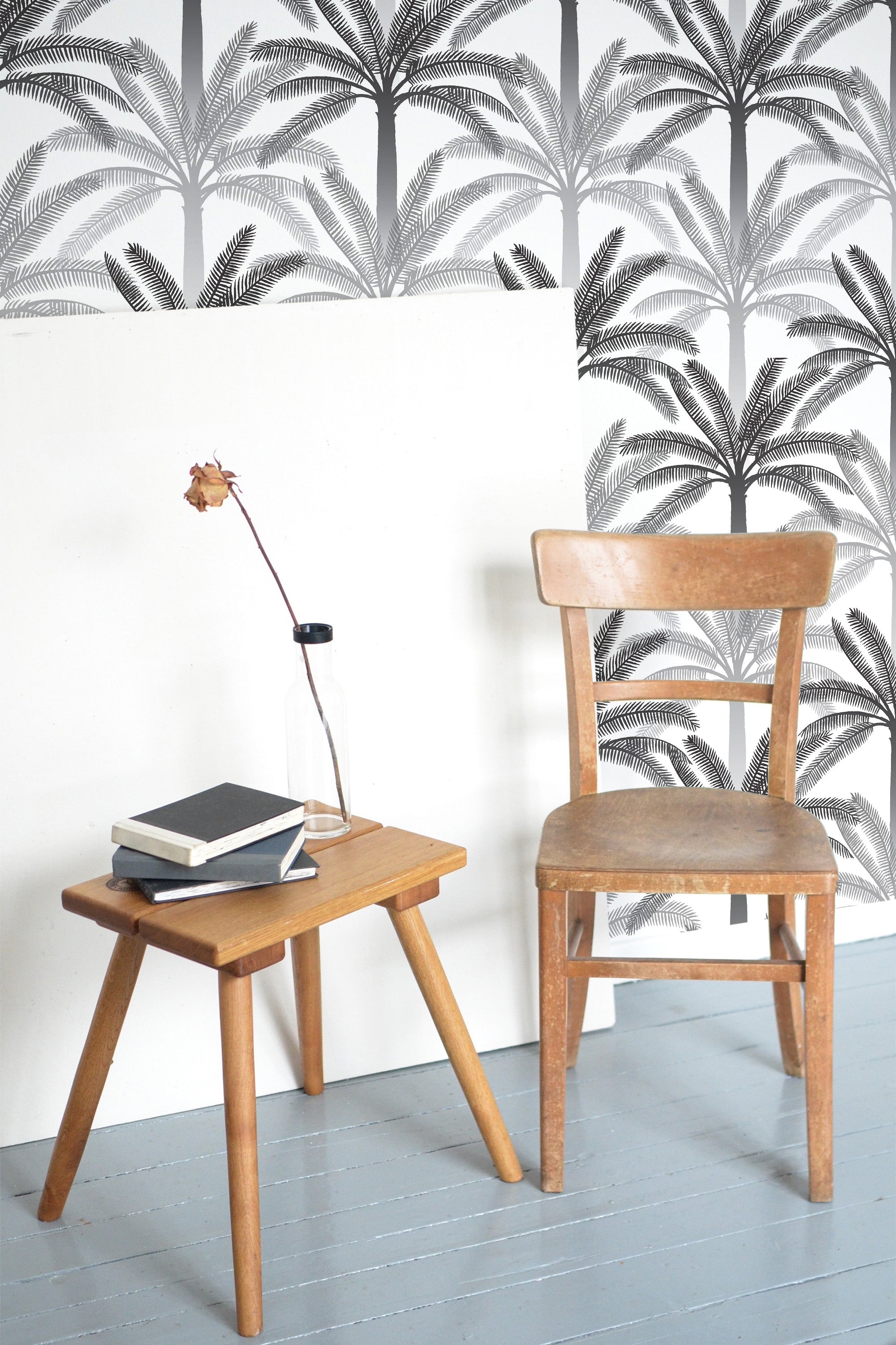 Self-adhesive gray and black palm tree wallpaper in a tropical pattern, creating a tranquil ambiance in the room with a blend of minimalist and natural elements.