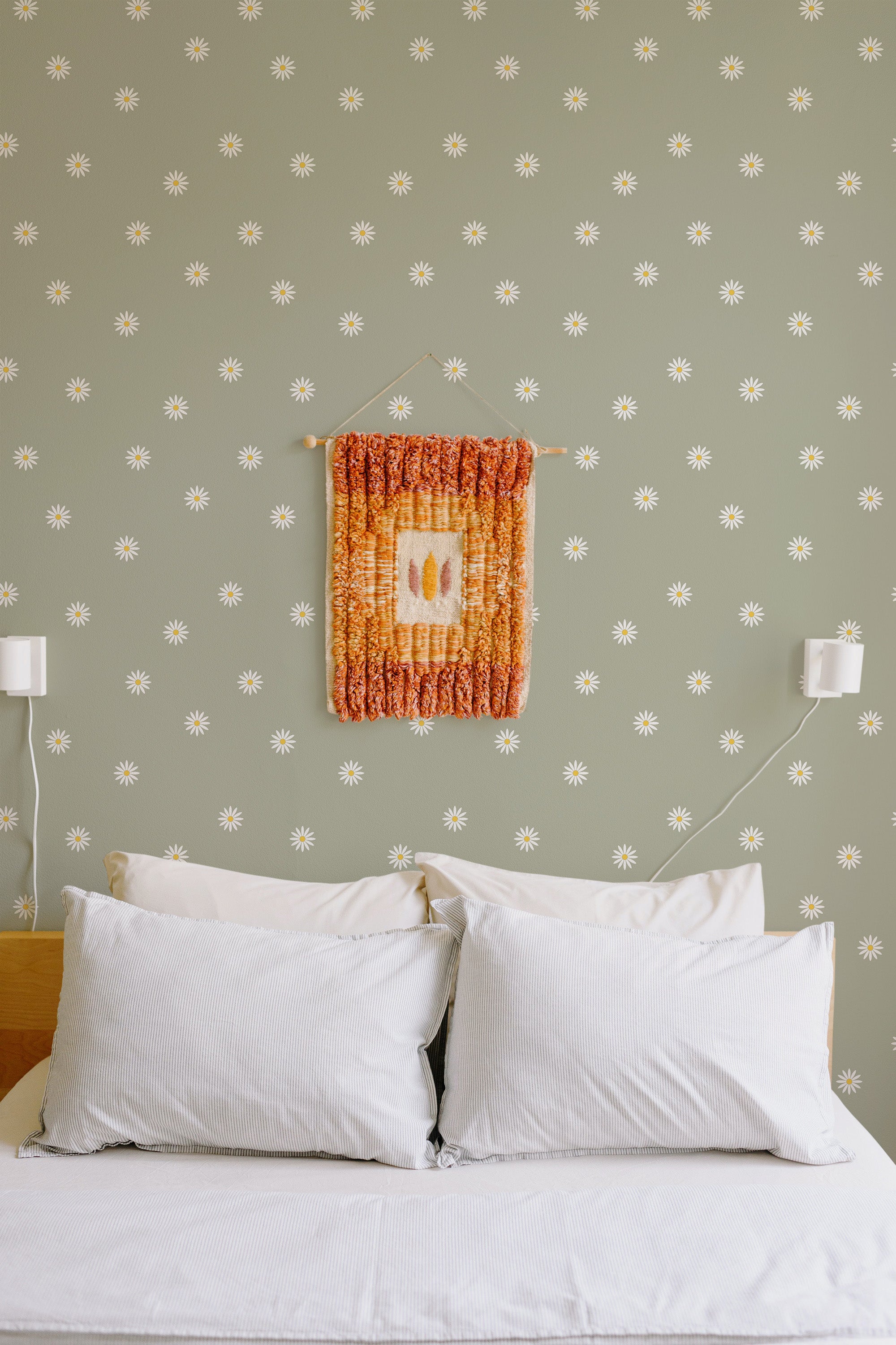 Self-adhesive wallpaper with a minimal daisy pattern on a muted green background. Small white daisies evenly spaced across the wall create a subtle and calming effect, perfect for a serene bedroom atmosphere.