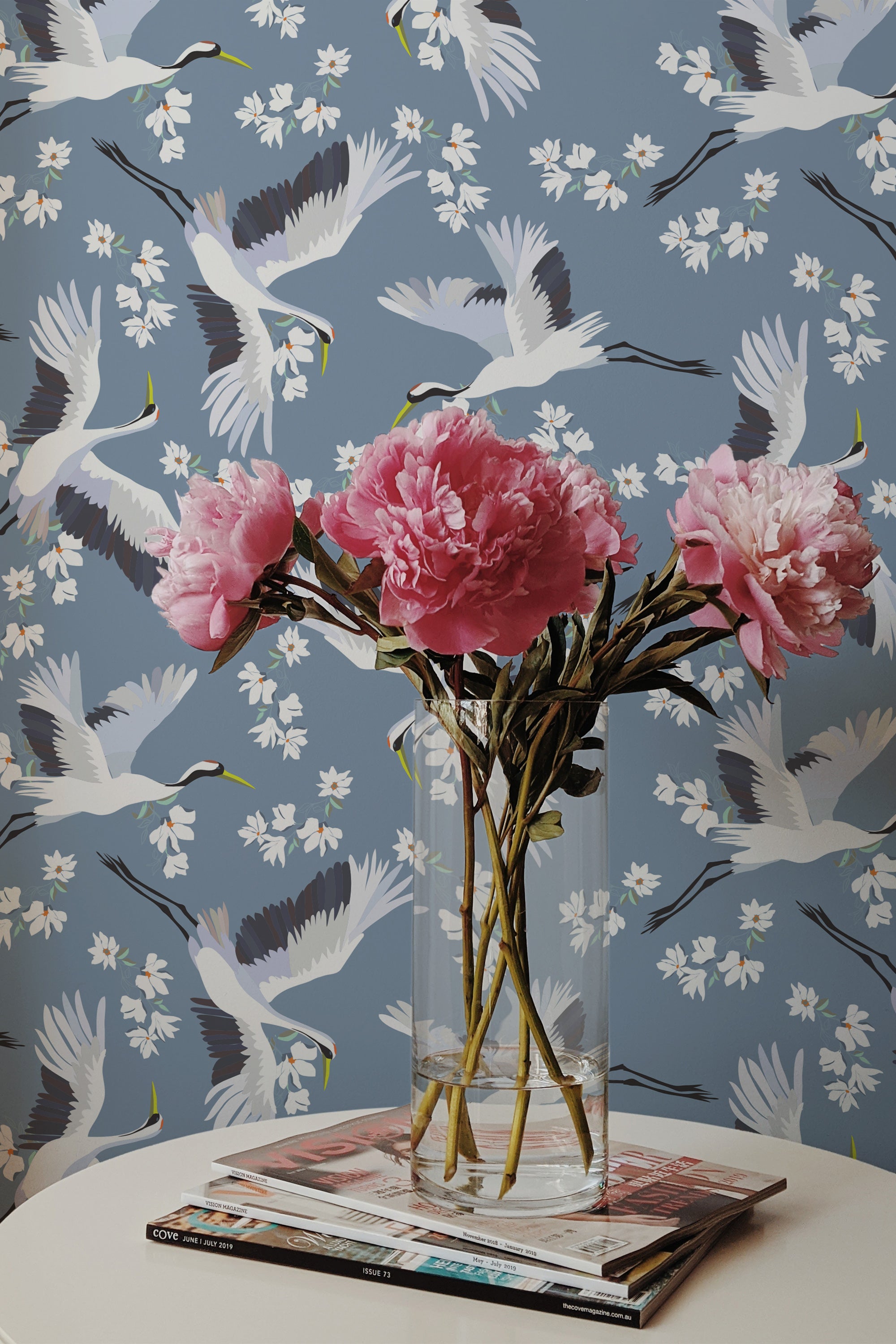 Self-adhesive wallpaper with a heron pattern in flight surrounded by white cherry blossoms on a muted blue background.