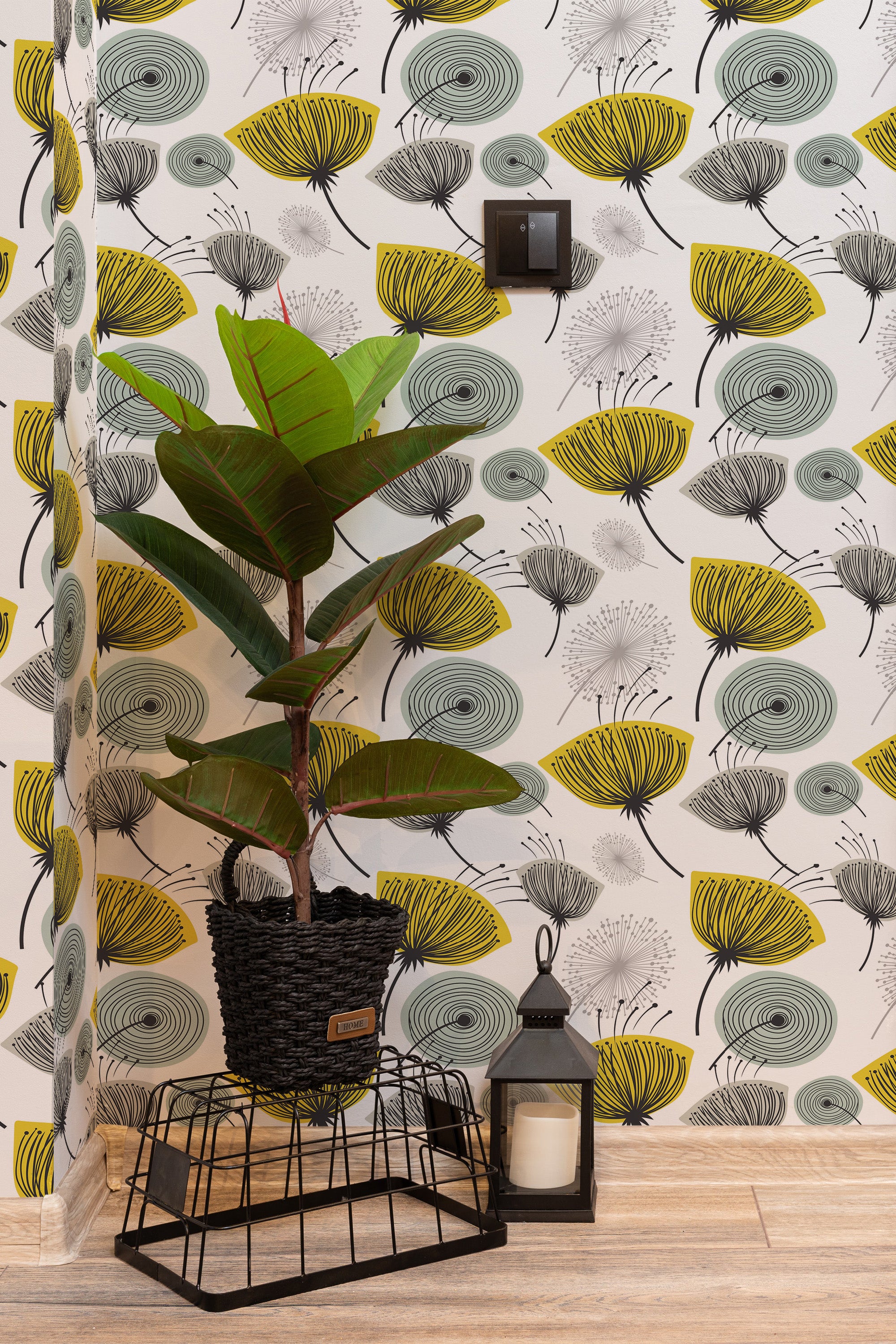 Self-adhesive mid-century dandelion wallpaper in a retro-inspired design with abstract dandelion motifs in shades of yellow, black, and gray on a white background.