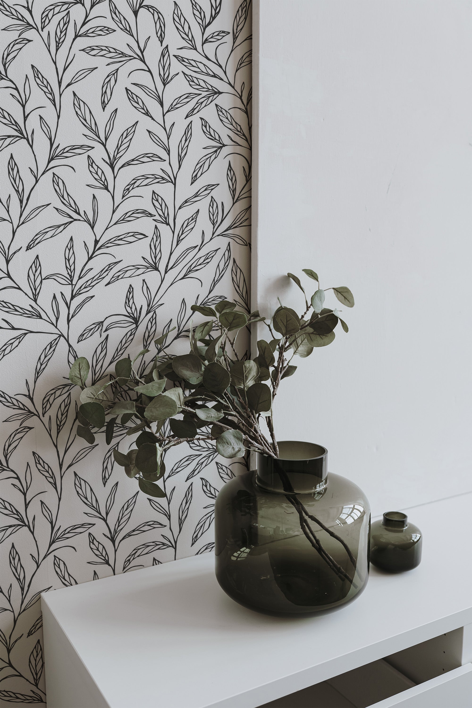 Self-adhesive wallpaper with a black leaf design against a light background, featuring intricate and delicate leaves in a natural, flowing pattern.