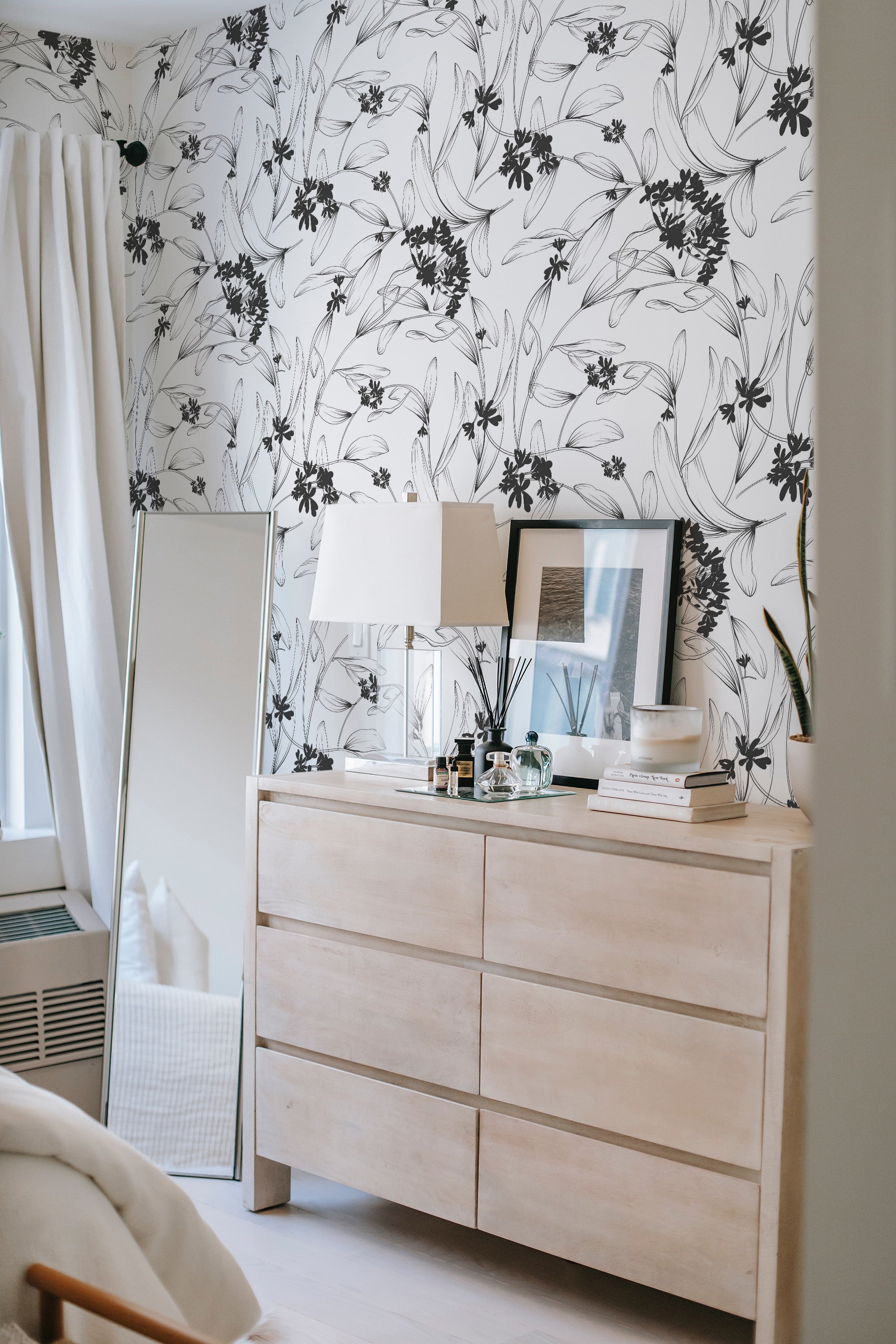 A room with walls adorned in Aesthetic floral wallpaper, with black and white floral patterns winding gracefully across a light background. Traditional wallpaper.