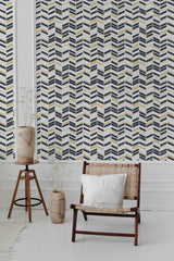 A room with Art Deco chevron wallpaper in navy blue, gold, and white, arranged in geometric zigzag patterns. Traditional wallpaper.