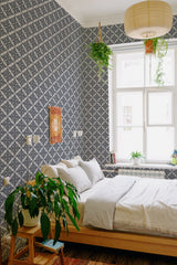 A room with art deco leaf patterned wallpaper in dark blue and white, creating a geometric lattice effect. Traditional wallpaper.