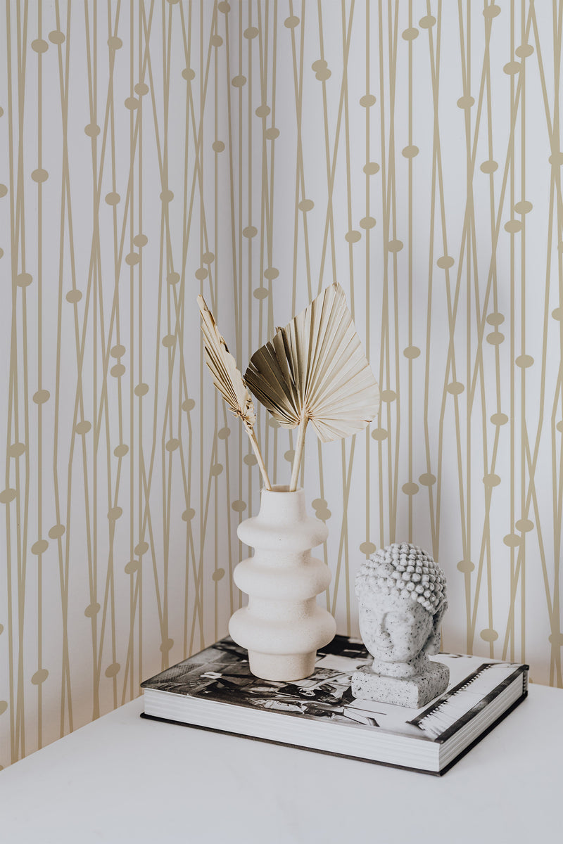 Self-adhesive wallpaper with a Retro Gold design, incorporating simple vertical lines interspersed with circular accents in subtle gold tones against a white background.