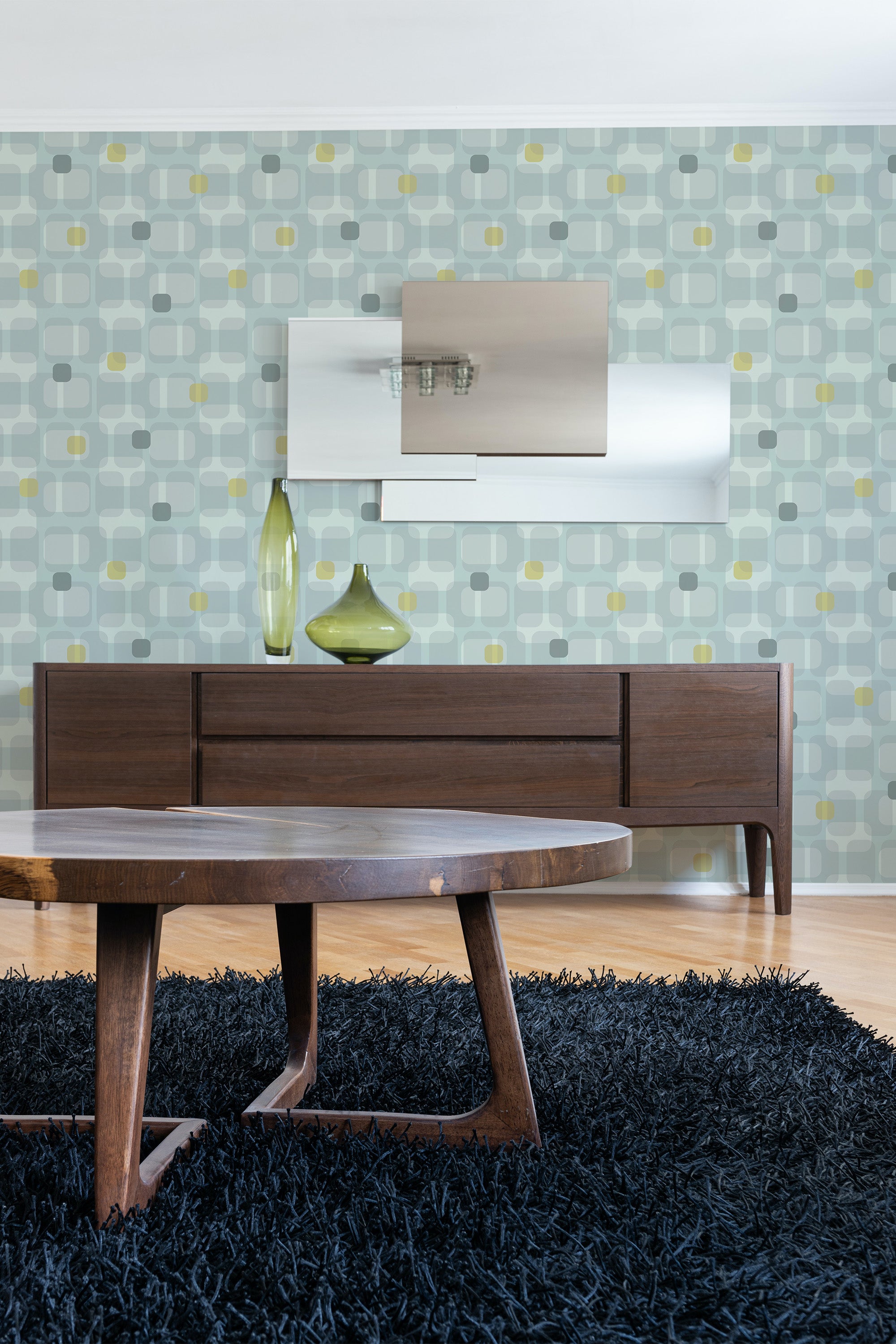 Room with wallpaper in a classic retro circle pattern in shades of gray, yellow, and light blue, complementing mid-century modern furniture. Traditional wallpaper.