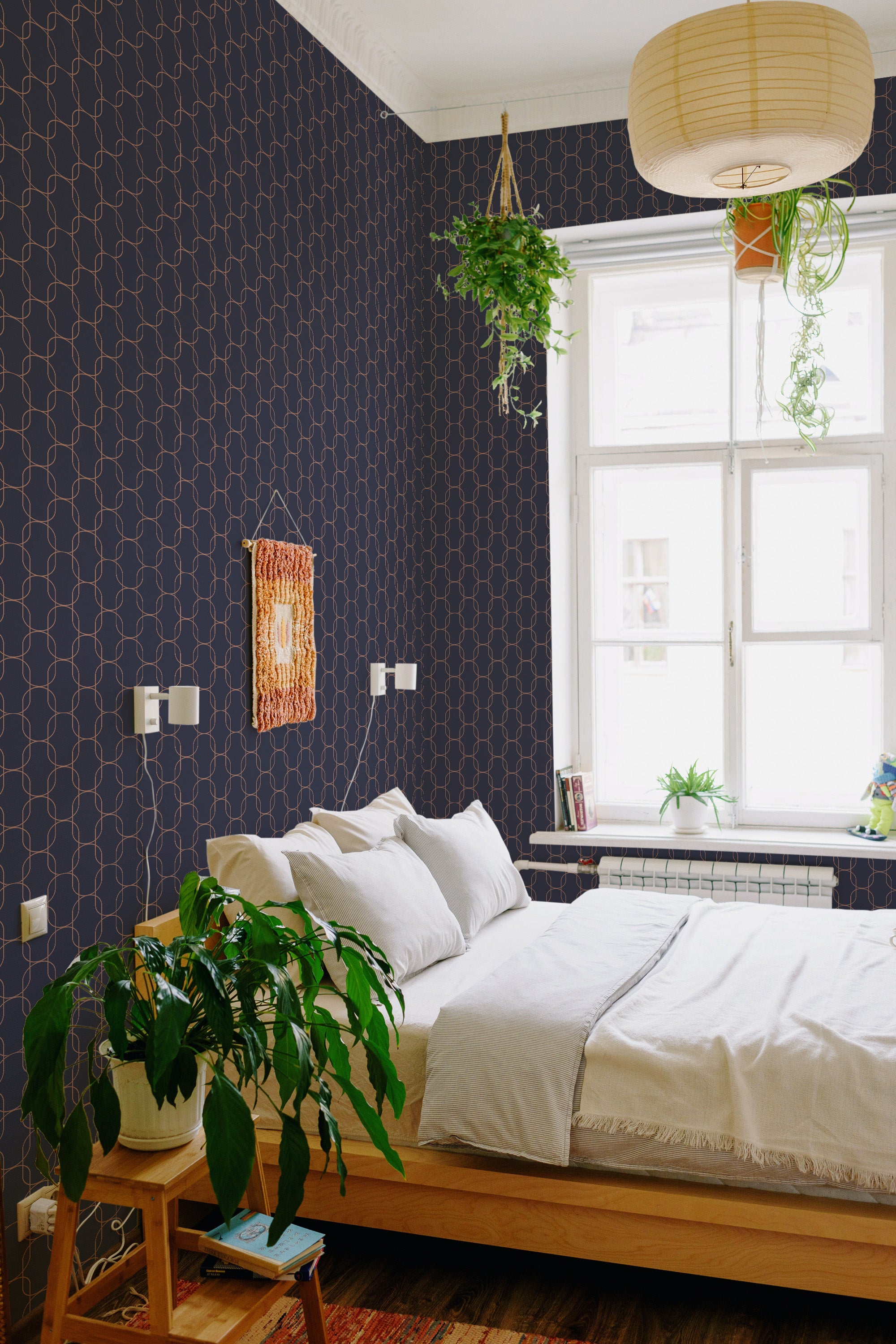 Wallpaper with an oval geometric pattern in dark tones and slender, interlocking ovals in a light, contrasting hue covers the wall. The design lends a modern yet timeless aesthetic to the cozy room, balancing the vintage feel of traditional wallpaper.