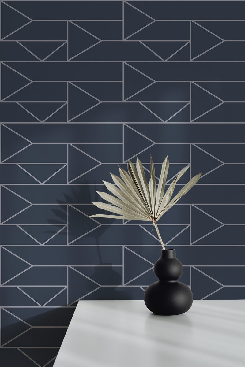 Self-adhesive wallpaper with a Retro modern design, featuring geometric patterns of arrows and triangles in silver lines on a dark navy blue background.