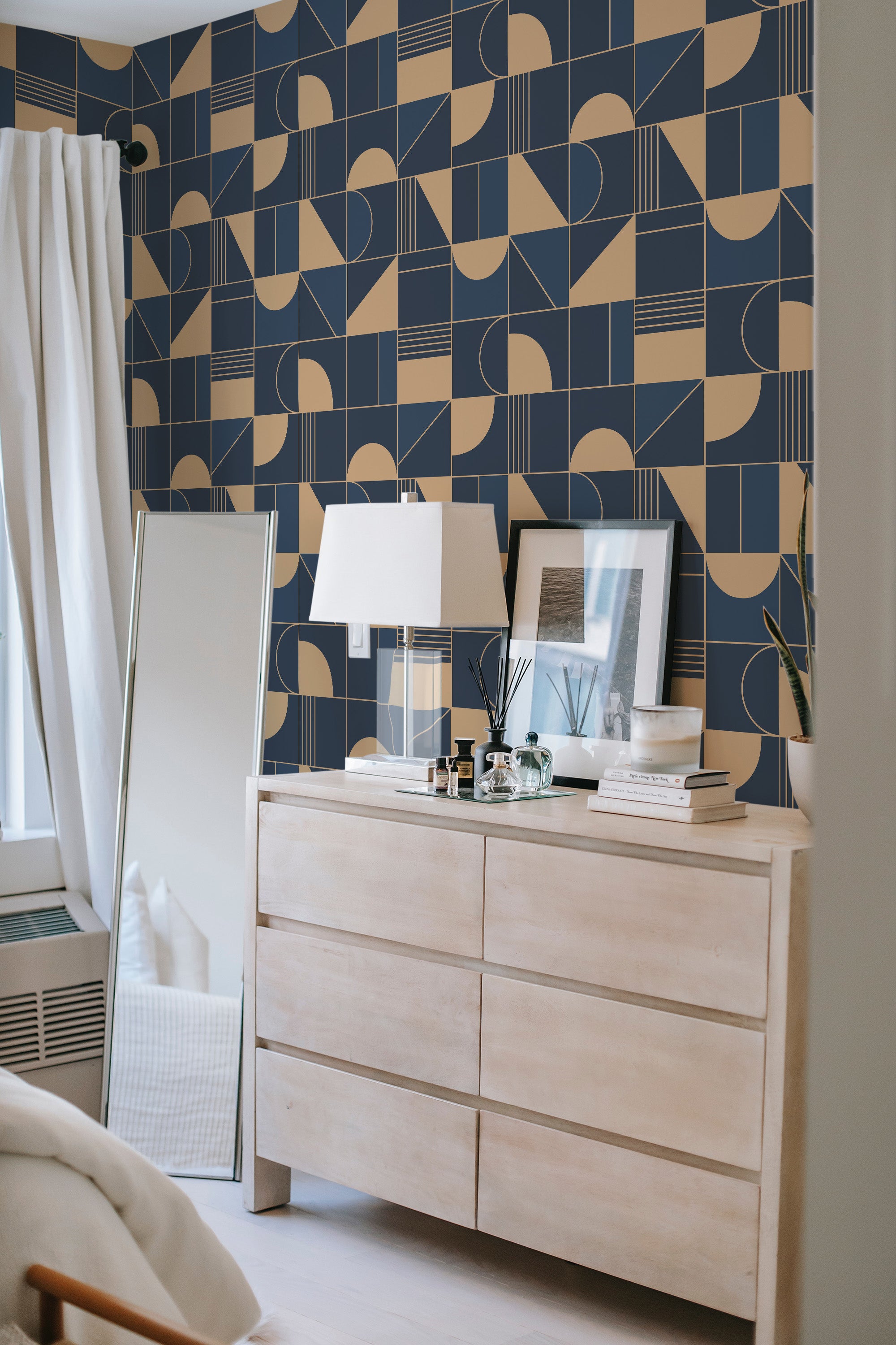 A room with blue and beige geometric-patterned wallpaper, featuring abstract shapes including circles, arcs, and squares in a uniform, repeating arrangement, set against a backdrop of light neutral-colored furniture���a modern design reminiscent of traditional wallpaper.