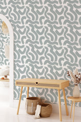 A room with wallpaper in a wavy, abstract Big Brush Lines pattern in soft blue and white tones. Traditional wallpaper.