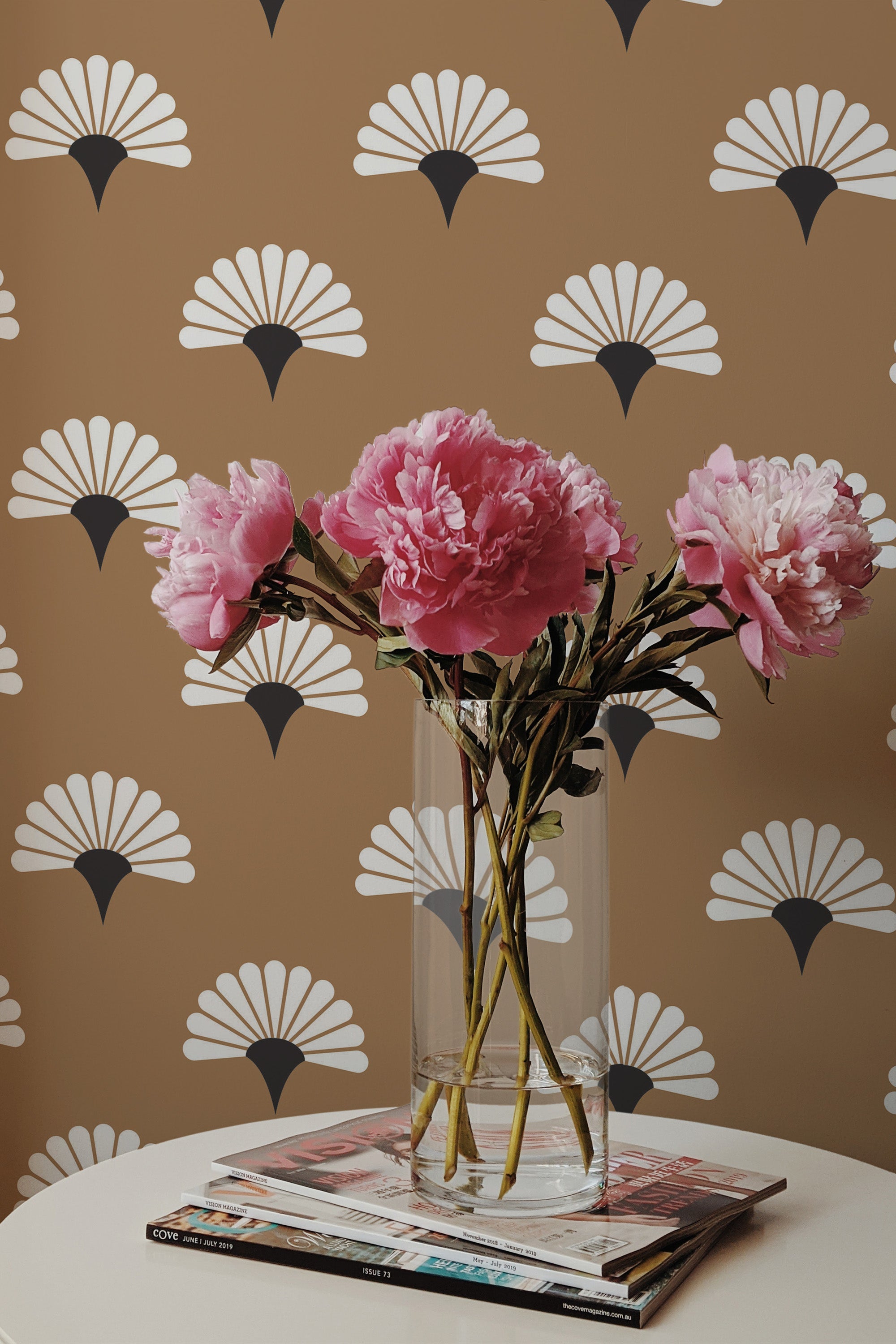Self-adhesive wallpaper with a Japanese floral design, including stylized white flowers with black accents on a brown background, matching the real pink flowers on the table.
