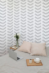 Self-adhesive herringbone dot pattern wallpaper in a room with a laptop, teapot, and cushions on the floor.