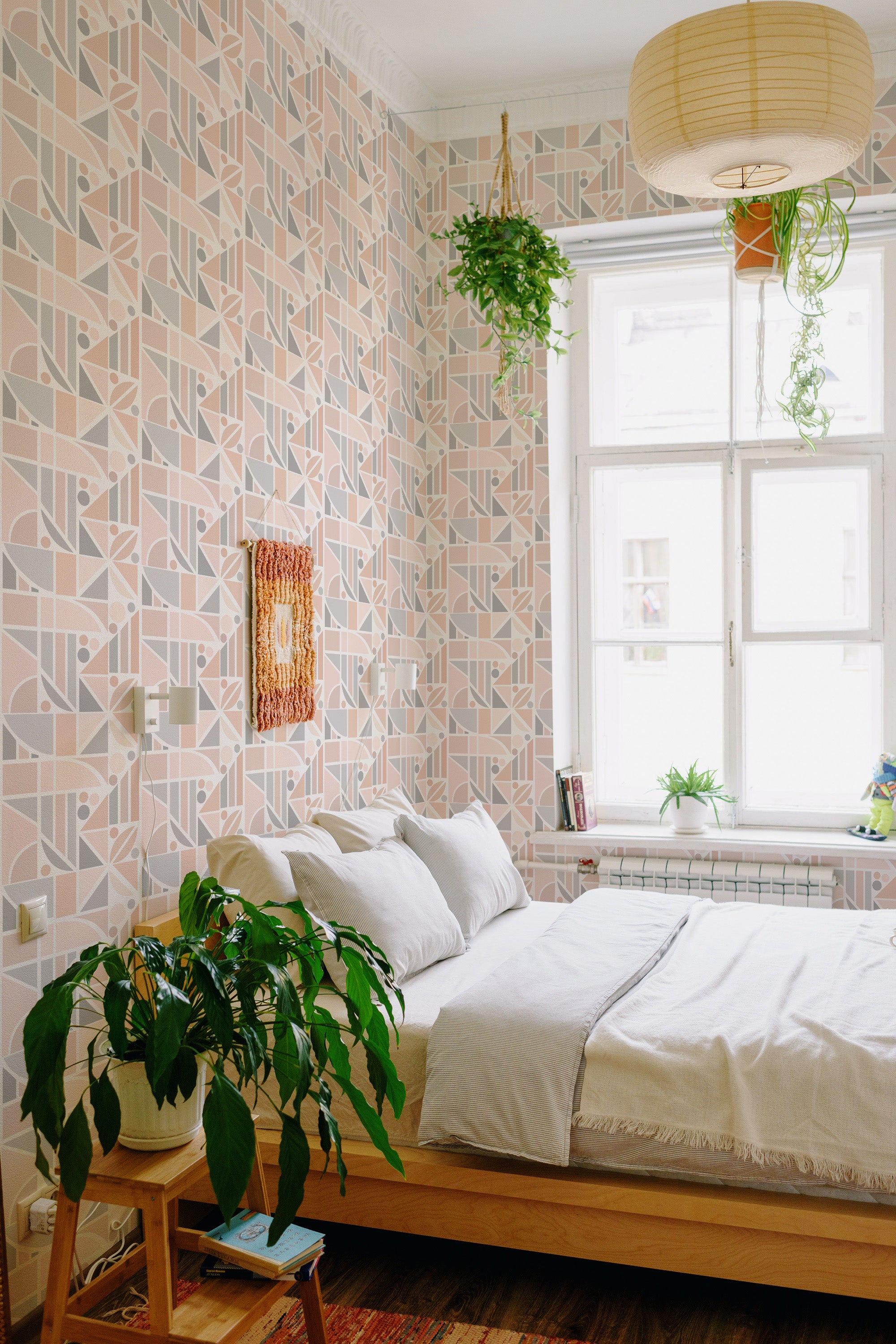 A cozy bedroom with walls covered in pastel-colored tile pattern wallpaper, complementing the natural light and green houseplants, traditional wallpaper.