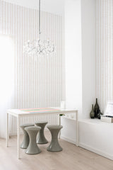 A room with wavy stripe patterned wallpaper running vertically, alternating between bold and faint lines for a rhythmic visual effect, contributing to a traditional wallpaper aesthetic.