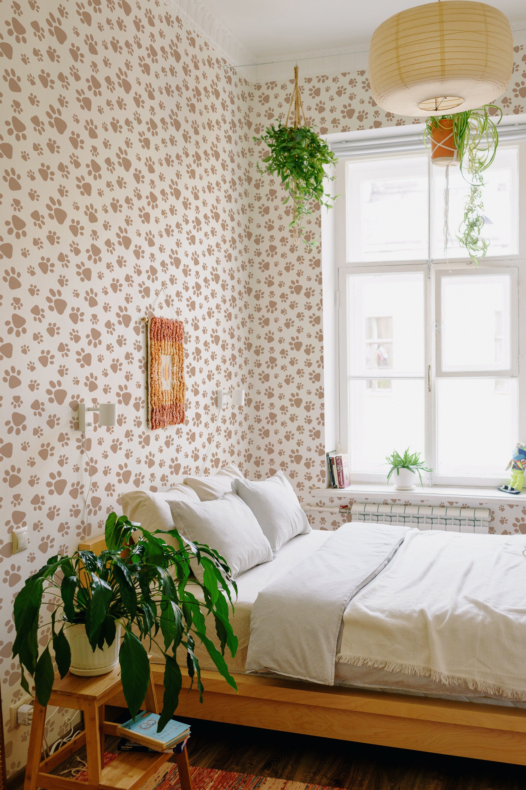 A cozy bedroom with walls covered in wallpaper with a dog paw print pattern in shades of brown and beige, complementing the natural light and green plants, giving the space a warm and inviting feel. Traditional wallpaper.