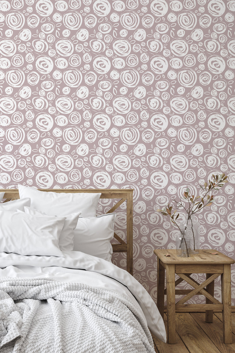 Self-adhesive wallpaper with a repeating pattern of stylized roses in a brushstroke design, adorning a bedroom wall behind a wooden bed and bedside table.