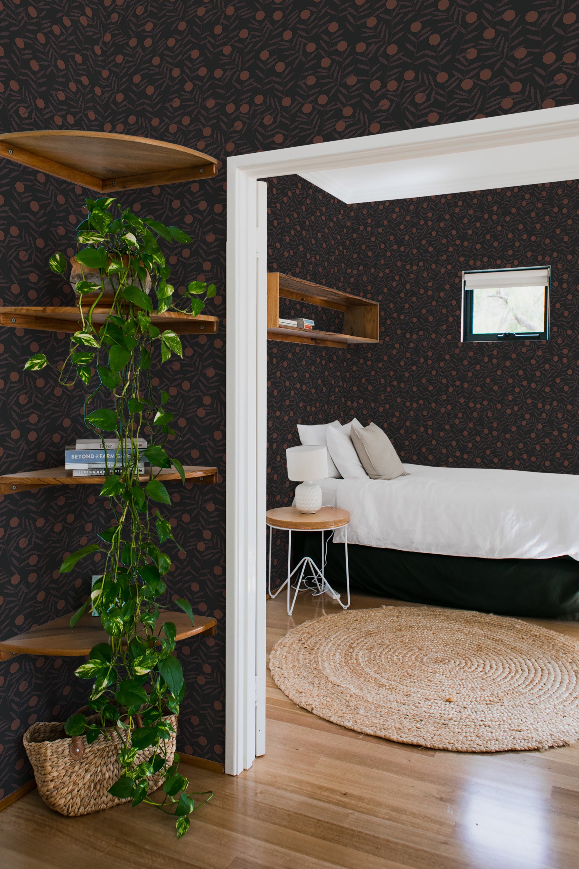 A room with dark wallpaper adorned with a bold citrus pattern, complemented by wooden shelves and a cozy bed, exuding a warm, traditional wallpaper ambiance.