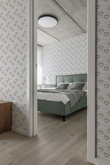 A bedroom with walls covered in heart line art wallpaper, with black continuous line hearts on a white background, adding a modern twist to traditional wallpaper.