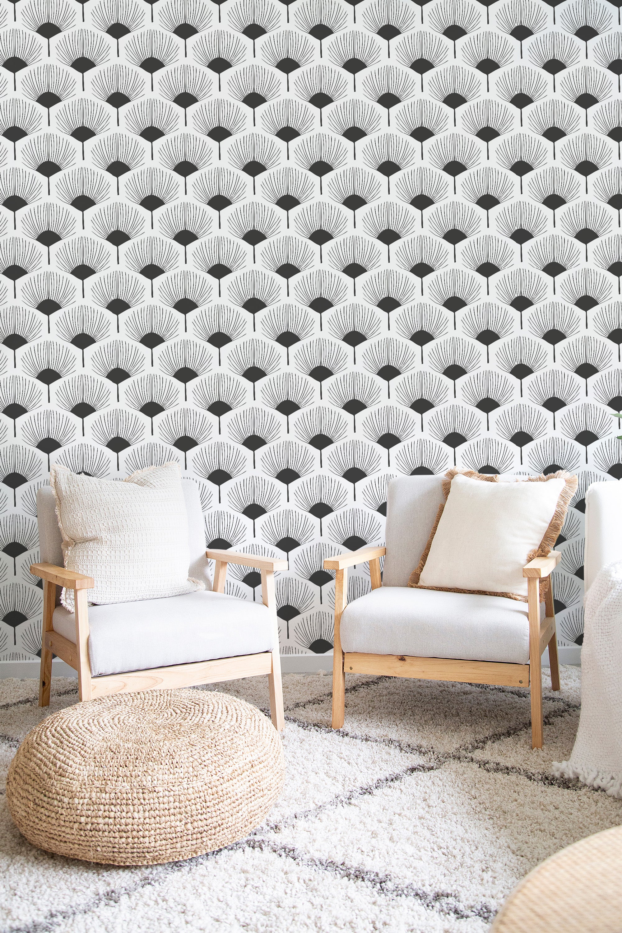 A room with a wall covered in black and white abstract floral-shaped traditional wallpaper.