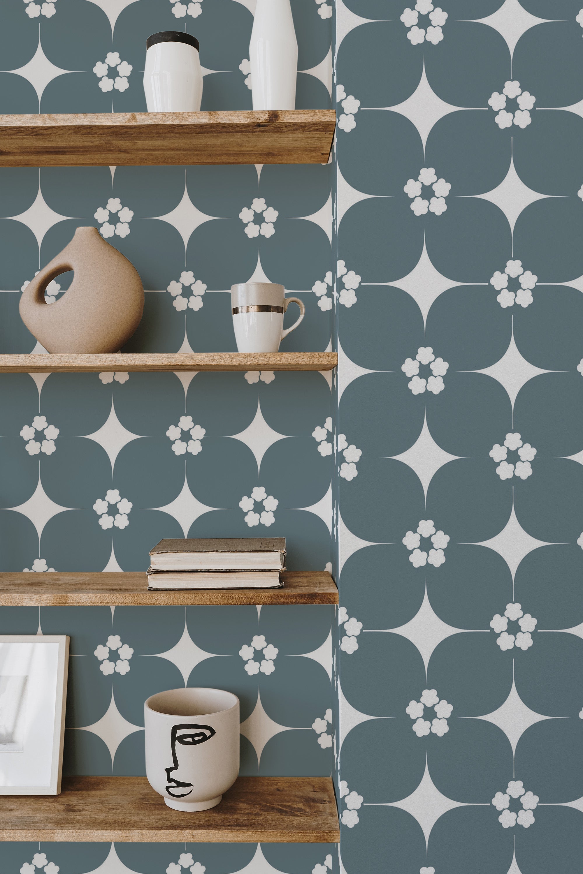 Self-adhesive Mid-century floral wallpaper with teal background and white stylized flowers, accentuated with small pink blossoms and dark green leaves.