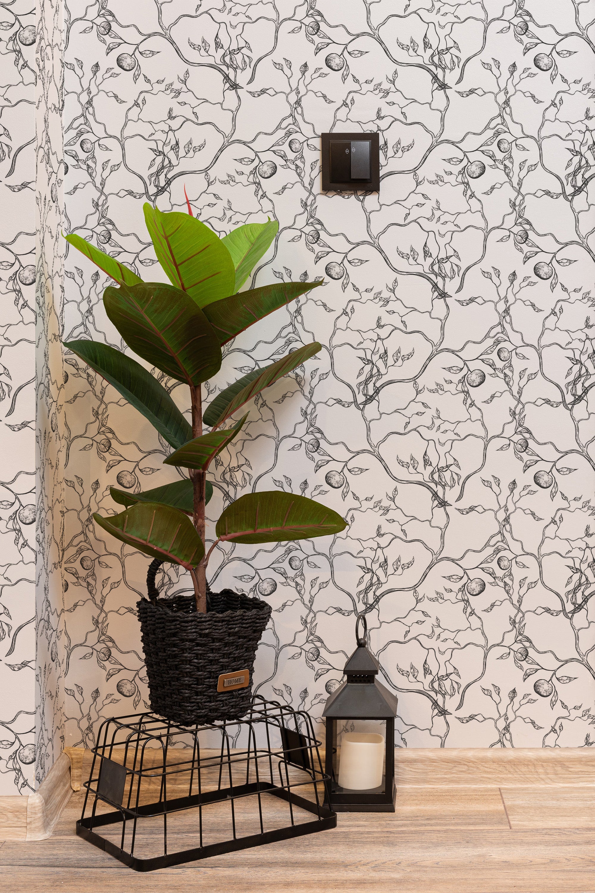 Self-adhesive wallpaper with a monochrome Japanese tree pattern on the wall behind a potted plant and a decorative lantern.