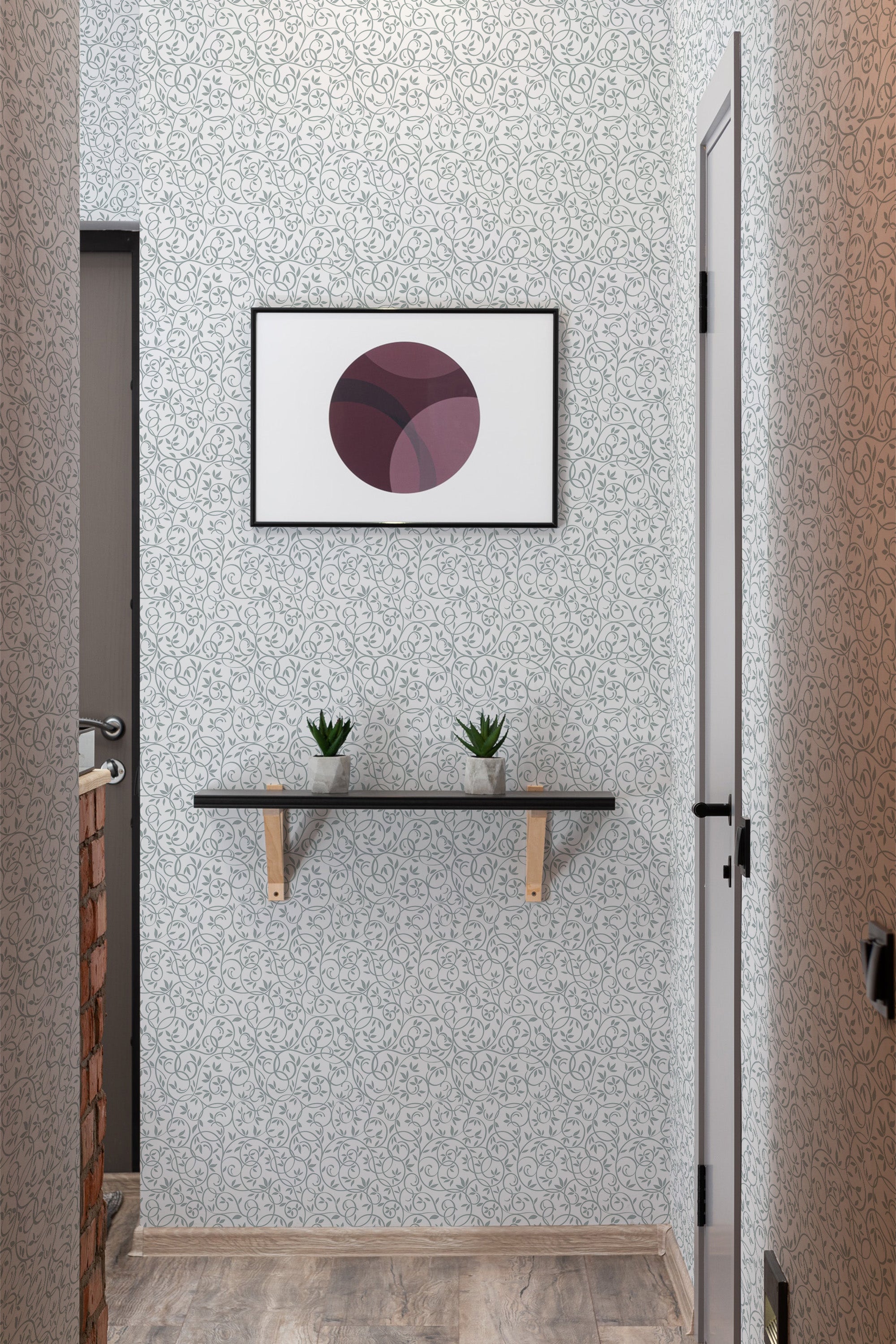 A room with gray and white patterned Ornament wallpaper, with a framed abstract art piece above a wooden shelf holding two small plants, finishing in a traditional wallpaper style.