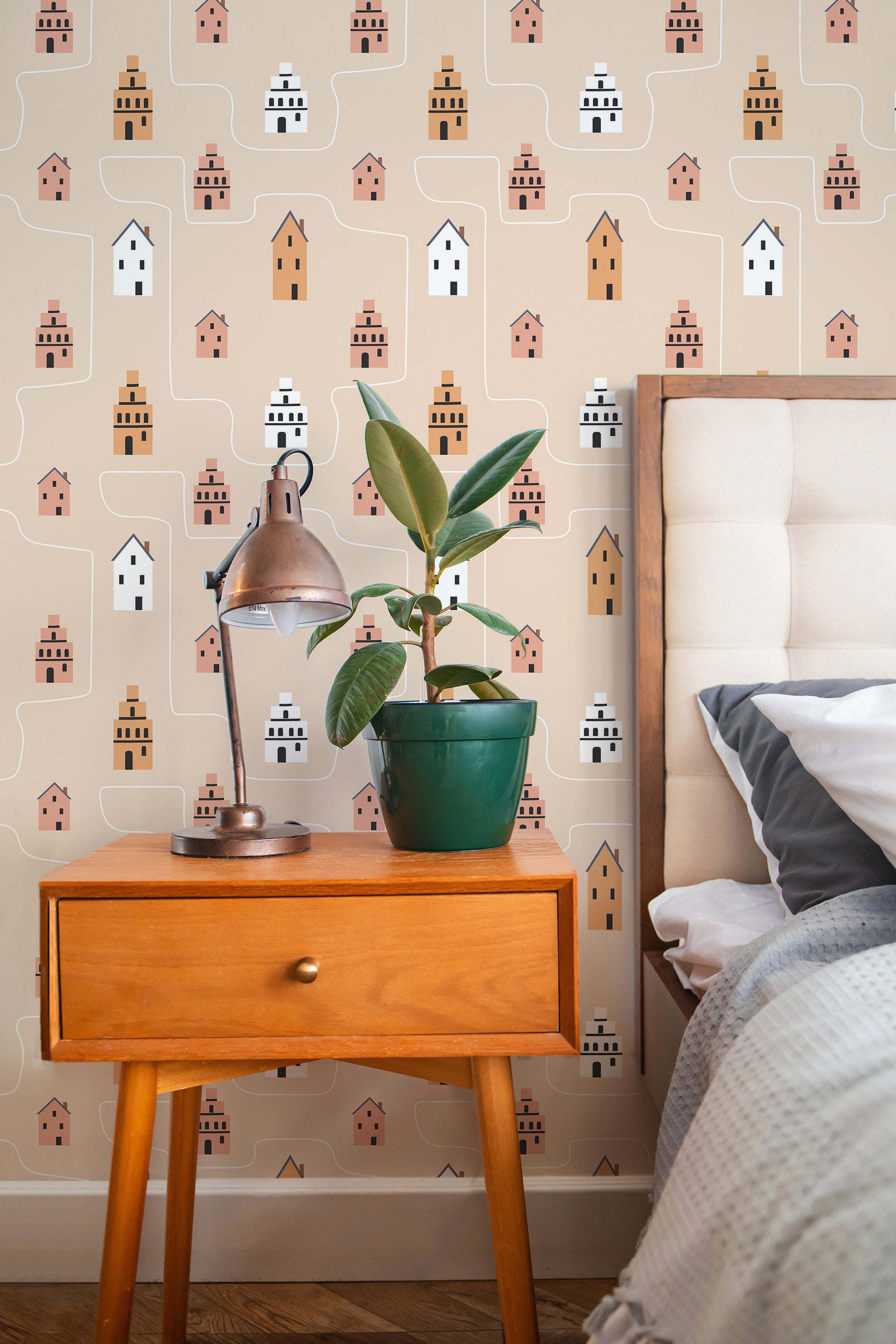 Self-adhesive Minimal Kids wallpaper with pastel-colored houses and cars pattern on a room wall, complementing a wooden bedside table and plant d��cor.