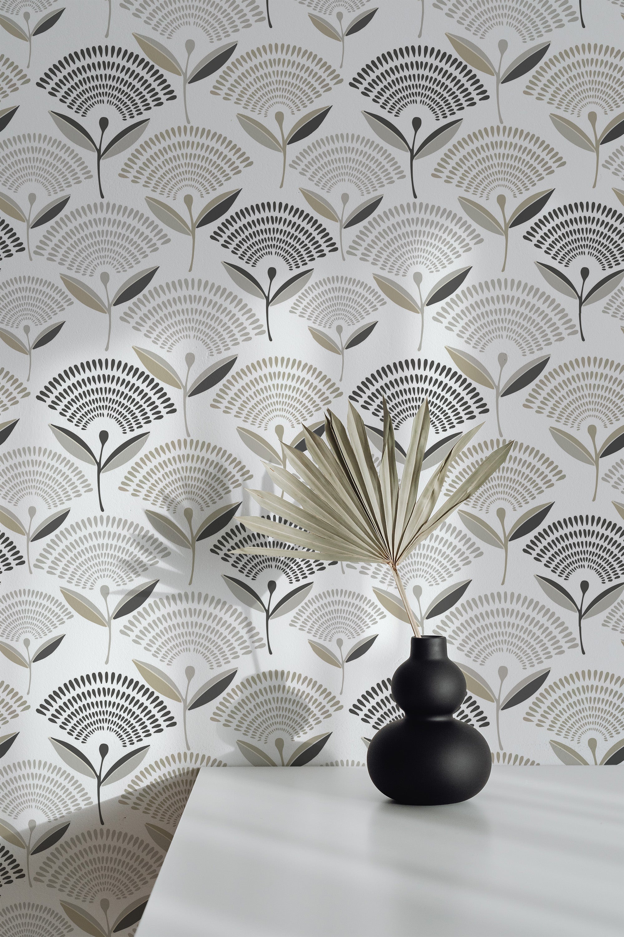 Self-adhesive wallpaper with a Mid-century flower design in subtle neutral tones of black, gray, and beige against a white background. A black vase with a decorative leaf sits on a white table in the foreground, complementing the vintage style.