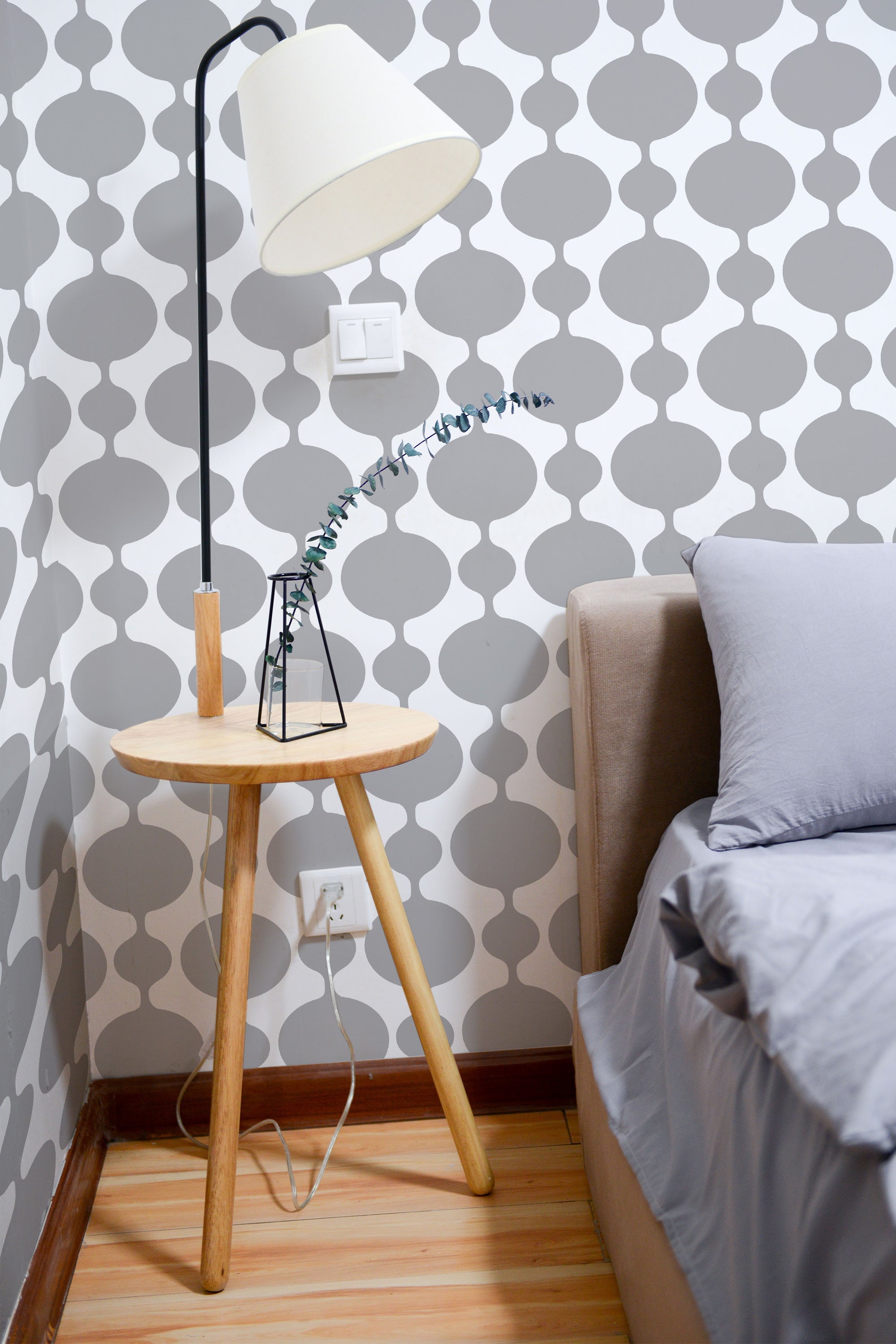 Self-adhesive wallpaper with a vintage seamless pattern of repeating gray and white abstract shapes, giving the room a retro and stylish vibe.